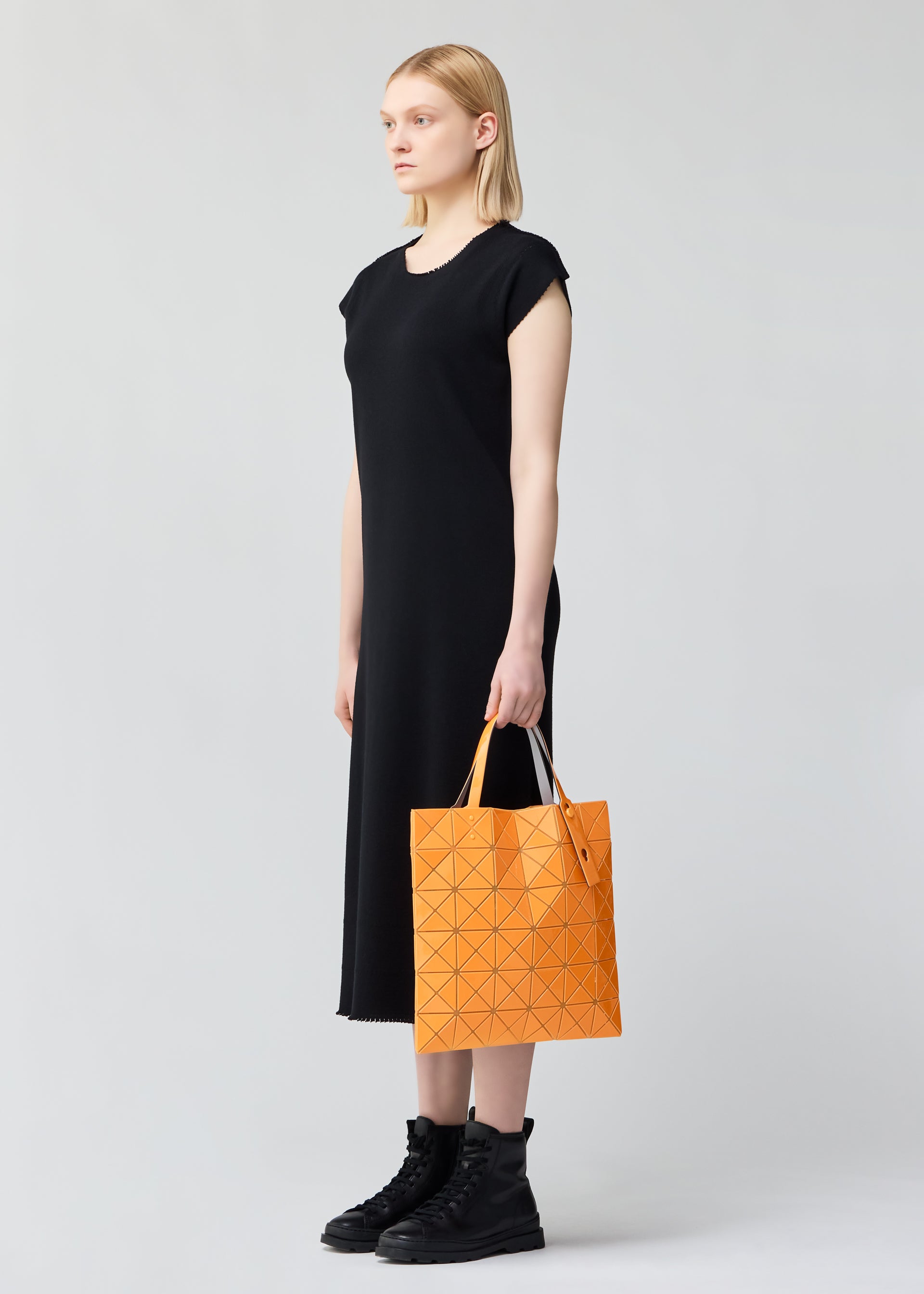 A model wears the BAO BAO ISSEY MIYAKE LUCENT ONE TONE tote.