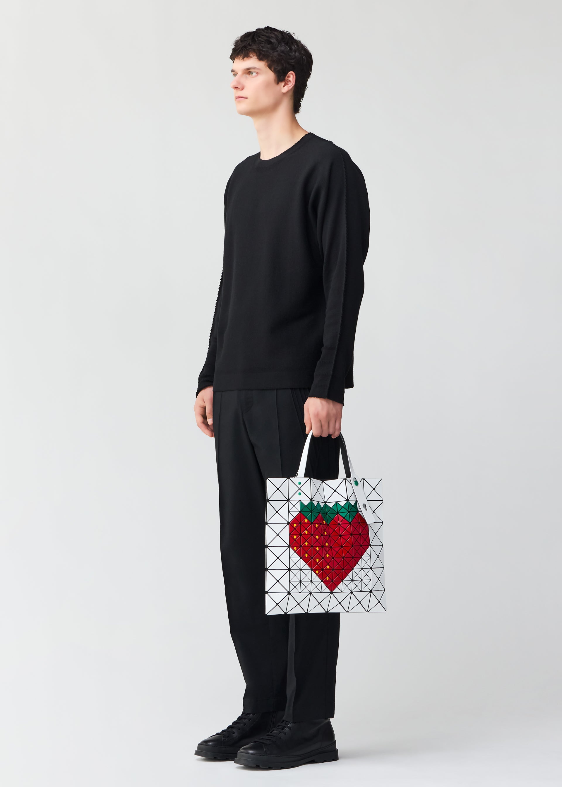A model wears the BAO BAO ISSEY MIYAKE FRUITS tote.