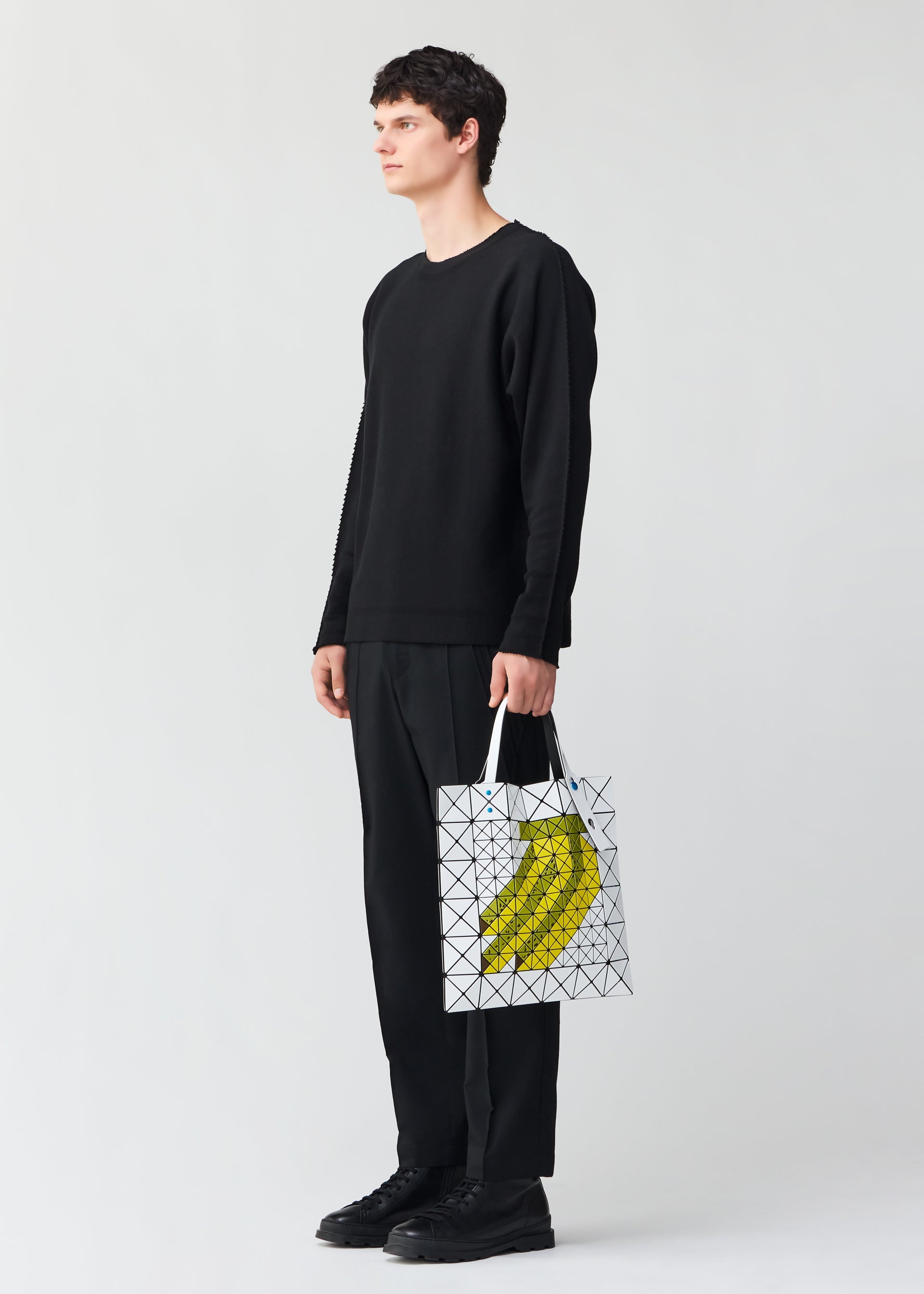 A model wears the BAO BAO ISSEY MIYAKE FRUITS tote.