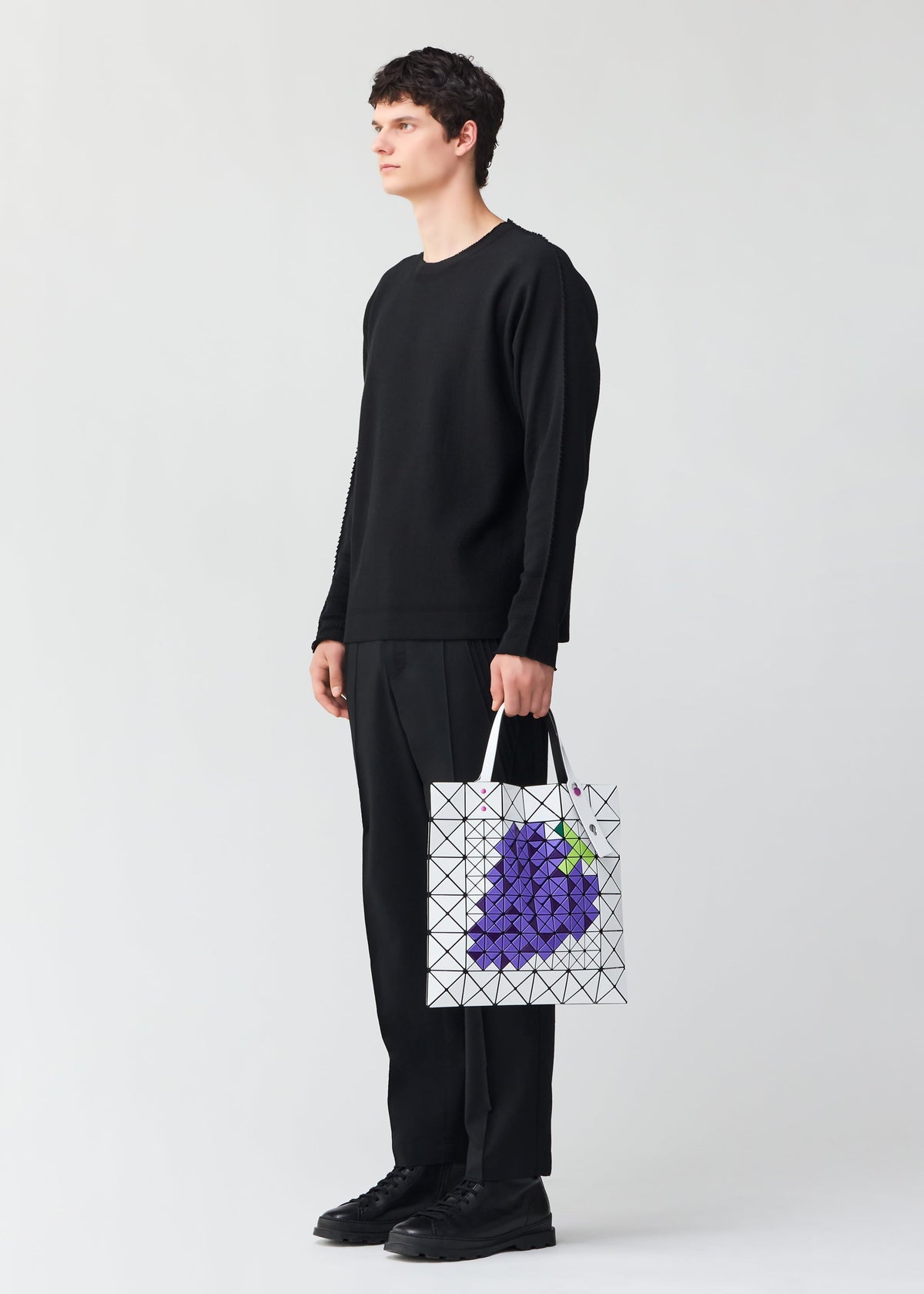 A model wears the BAO BAO ISSEY MIYAKE FRUITS tote.