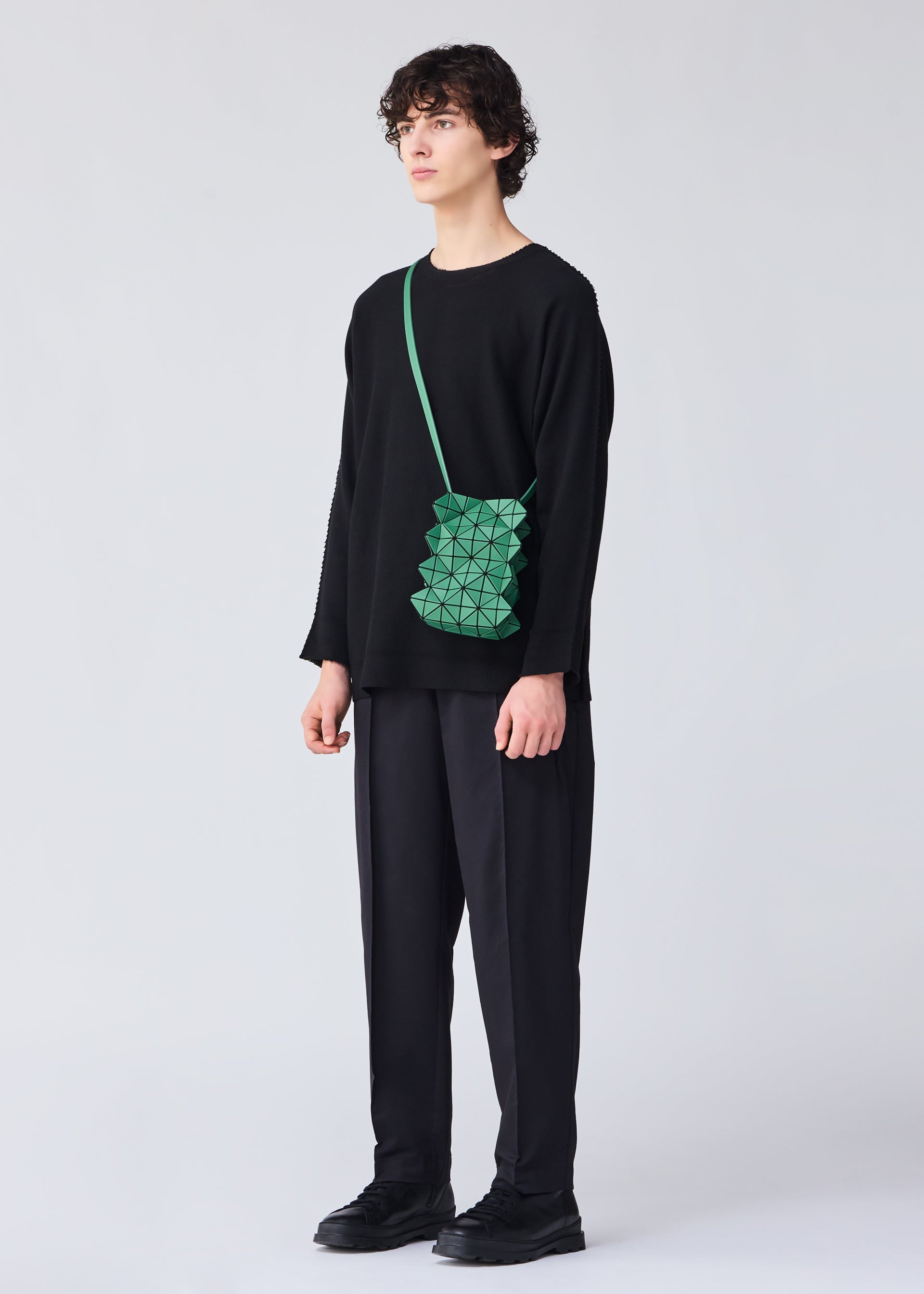 A model wears the BAO BAO ISSEY MIYAKE GROWTH shoulder bag.