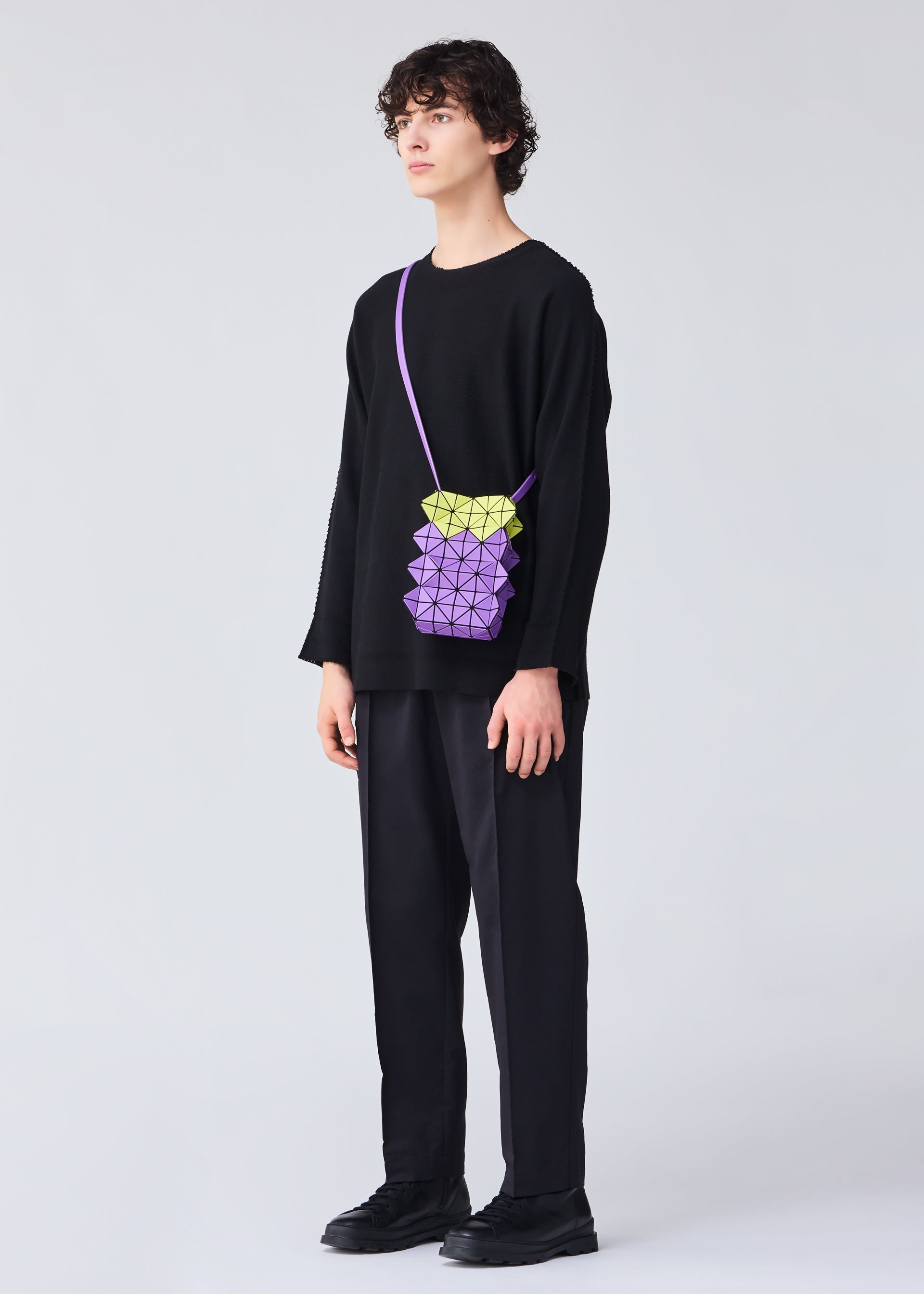 A model wears the BAO BAO ISSEY MIYAKE GROWTH shoulder bag.