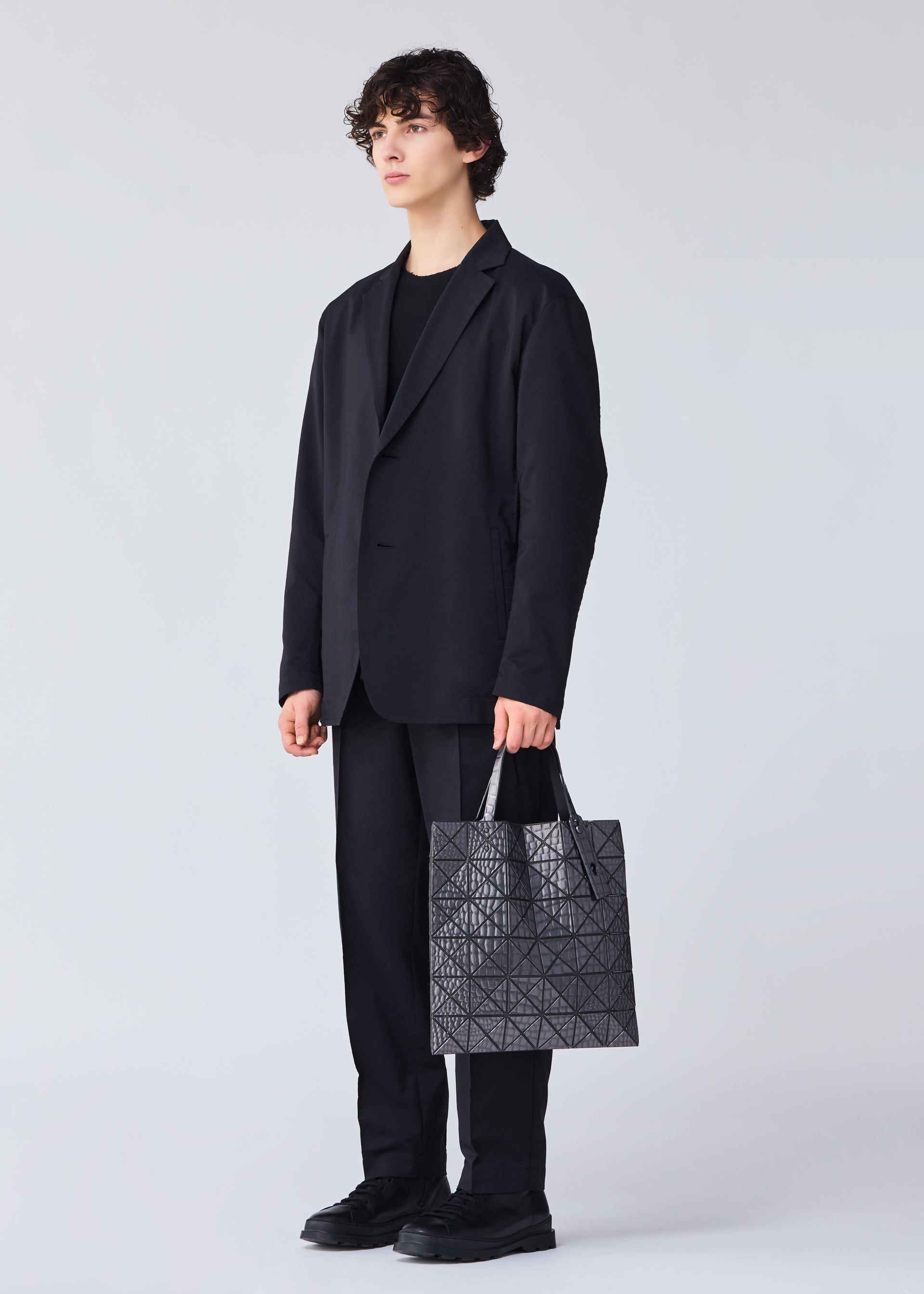 A model wears the BAO BAO ISSEY MIYAKE META KAIJU tote.