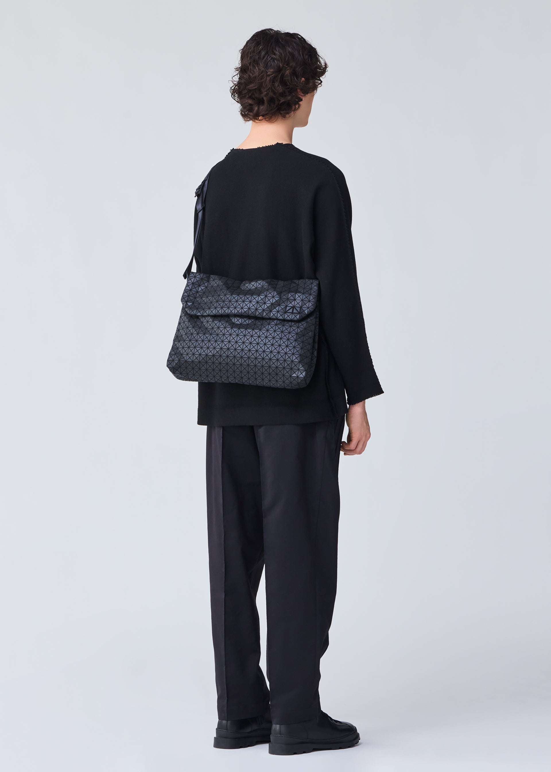 A model wears the BAO BAO ISSEY MIYAKE FROGGY shoulder bag.