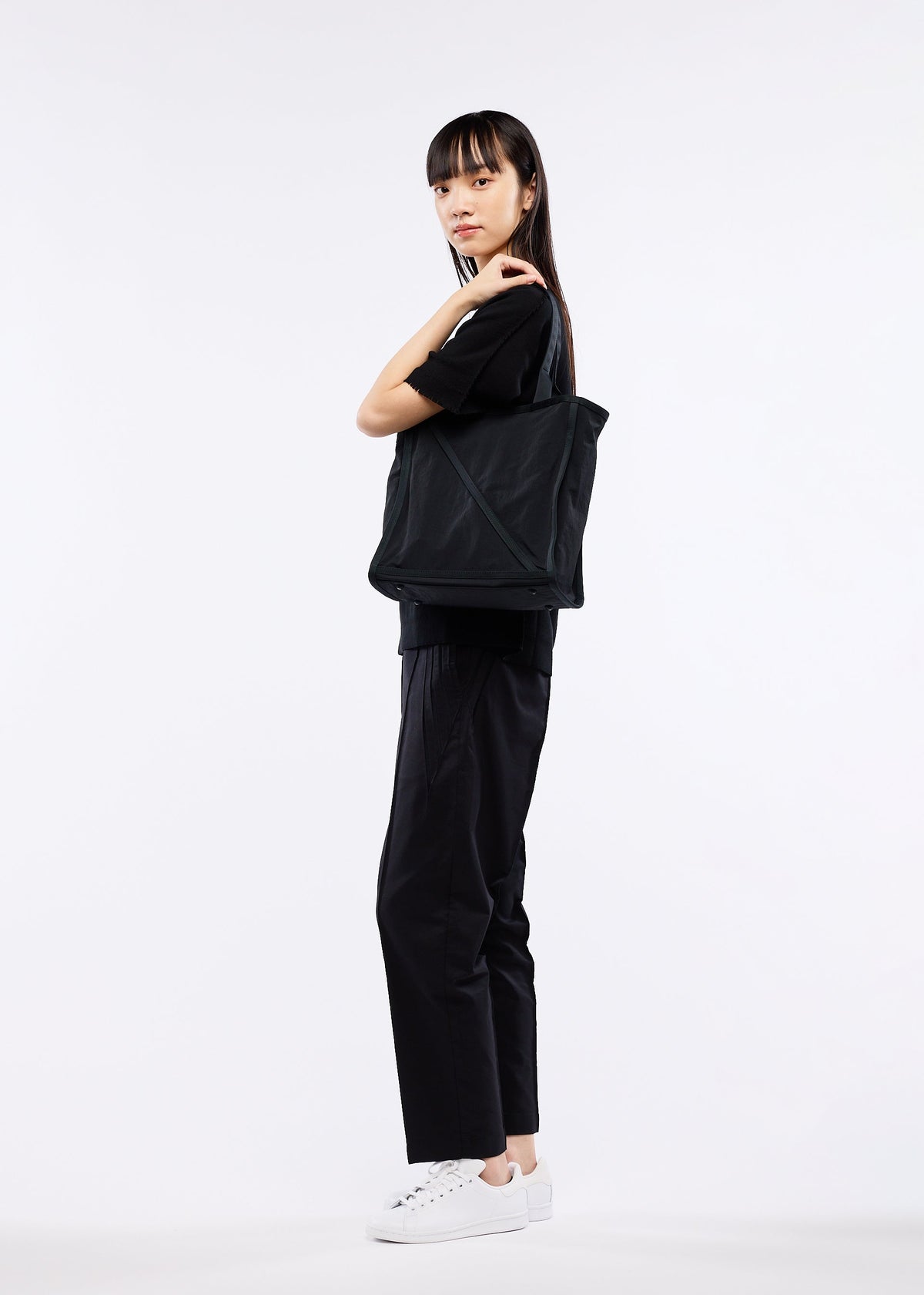A model wears the GOOD GOODS ISSEY MIYAKE WAKU bag.