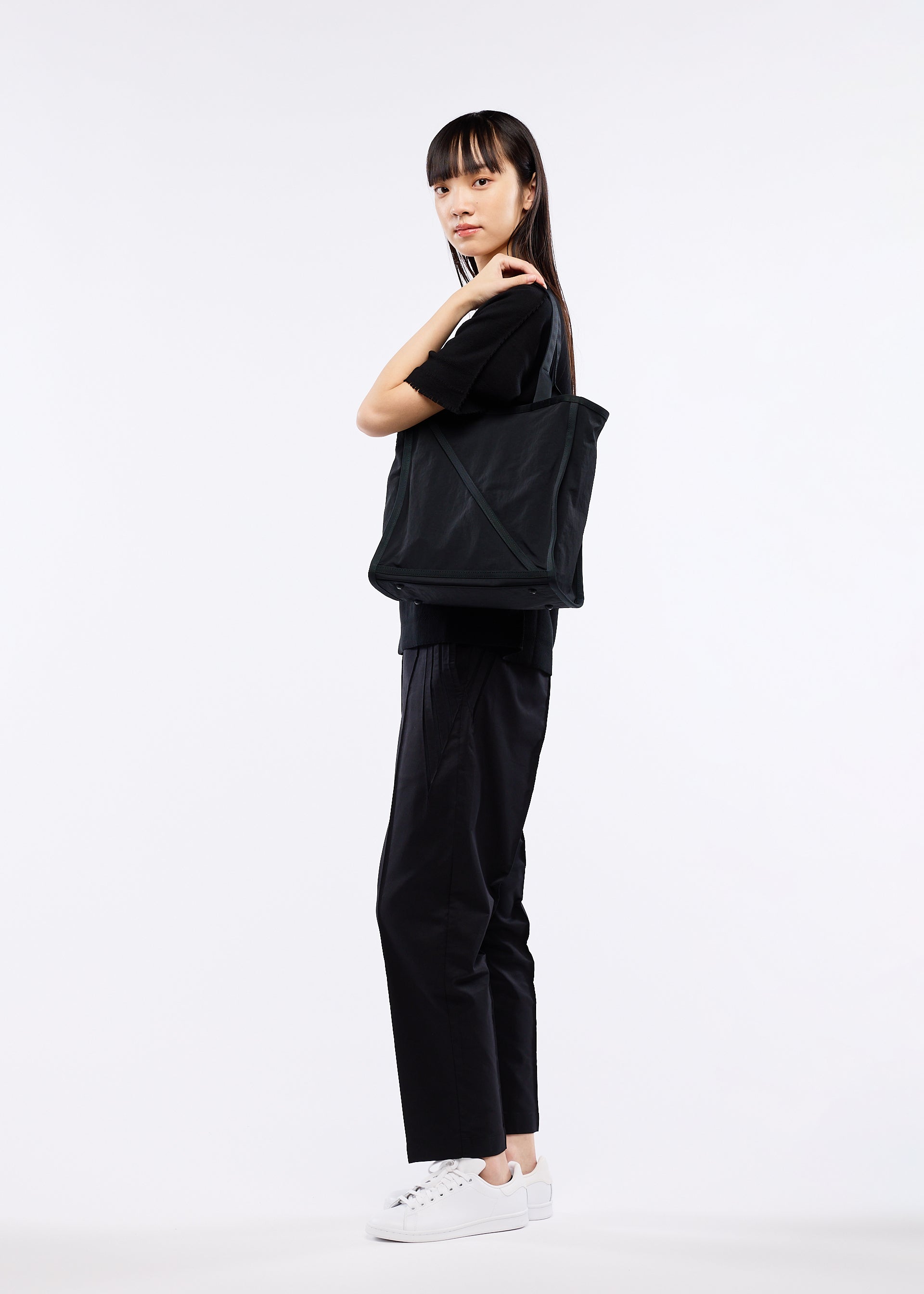 A model wears the GOOD GOODS ISSEY MIYAKE WAKU bag.