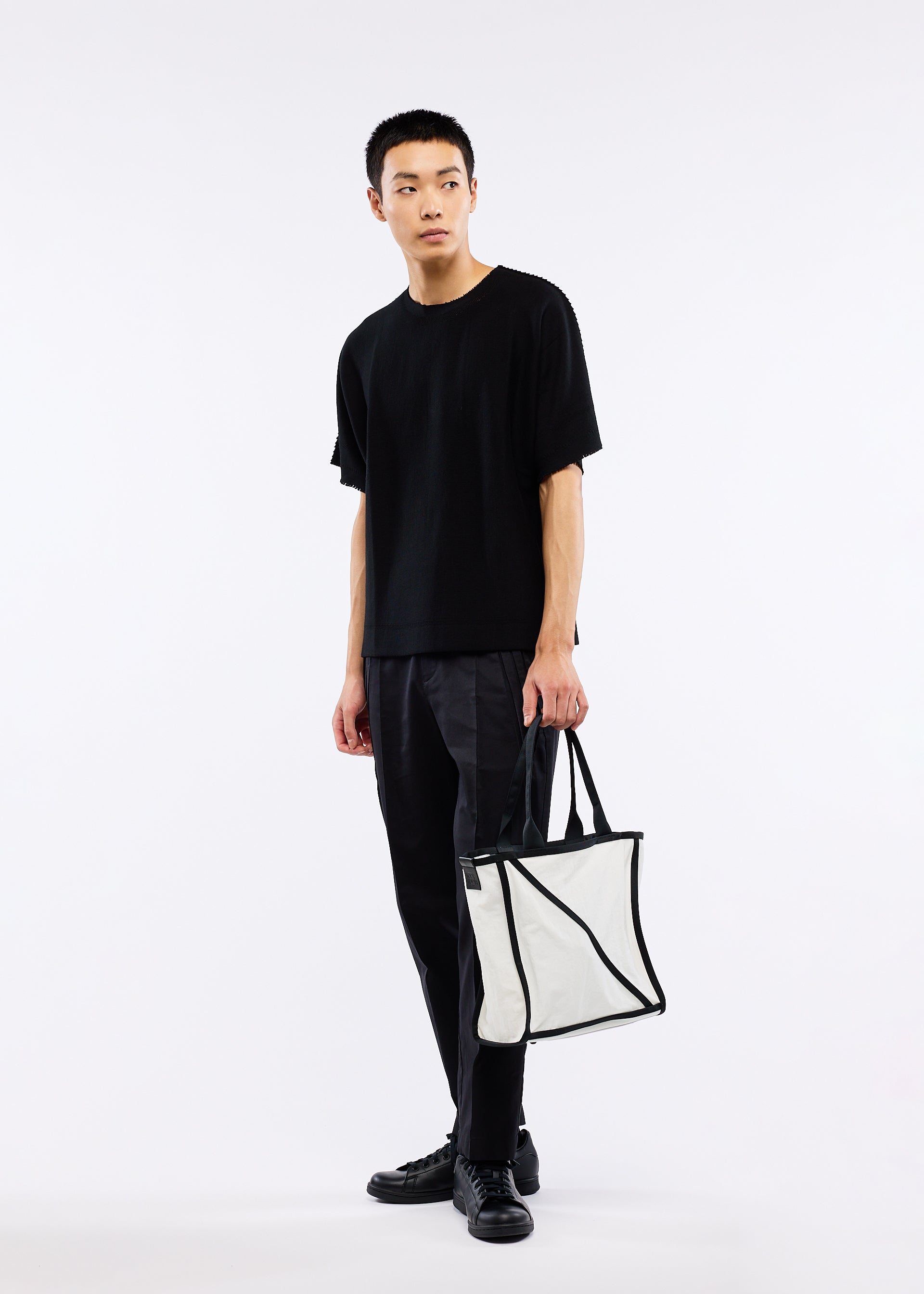 A model wears the GOOD GOODS ISSEY MIYAKE WAKU bag.