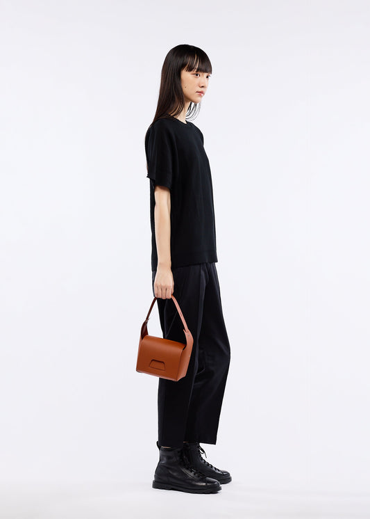 A model wears the GOOD GOODS ISSEY MIYAKE BOX bag.