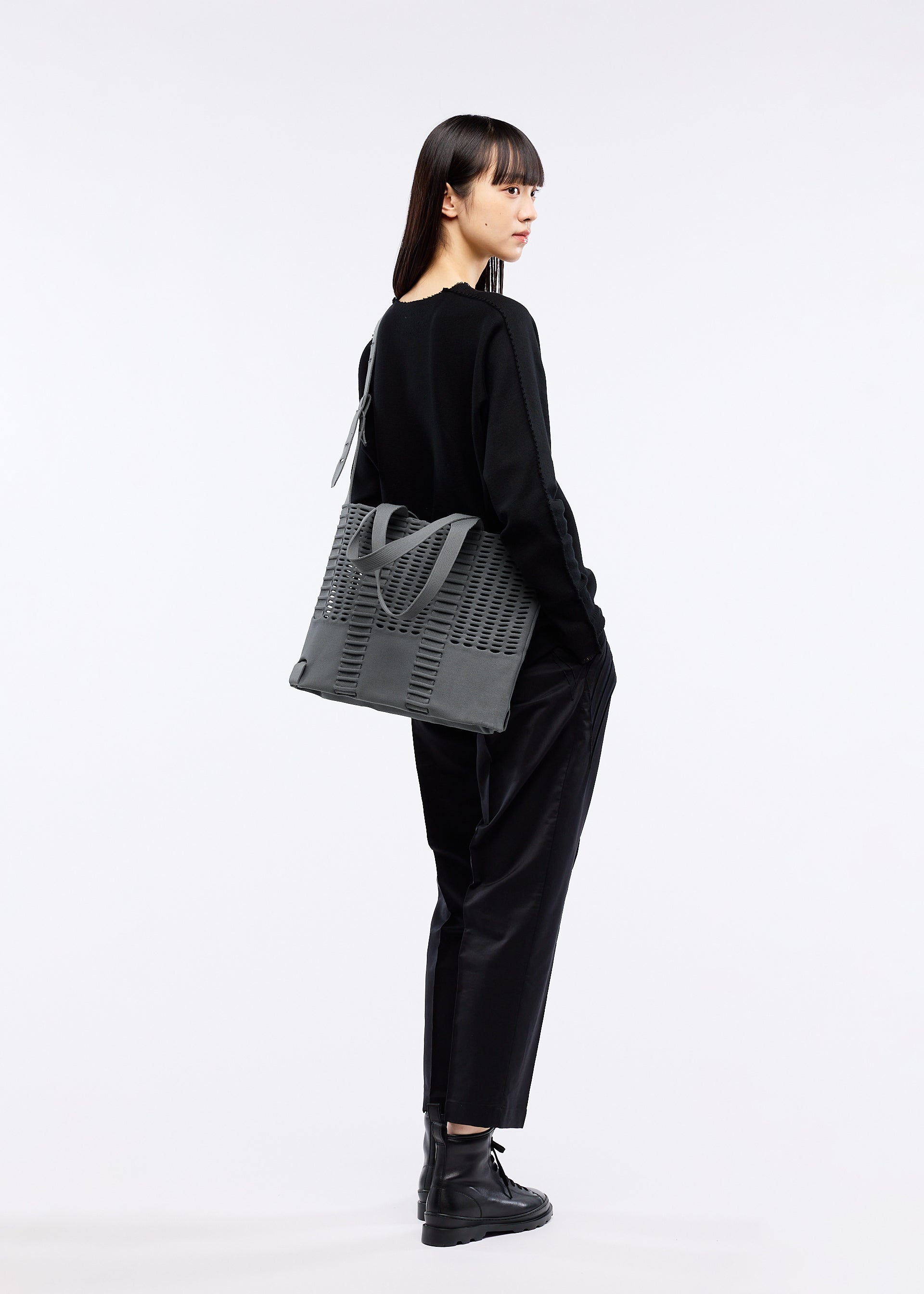 A model wears the GOOD GOODS ISSEY MIYAKE MOKKO MONO bag.