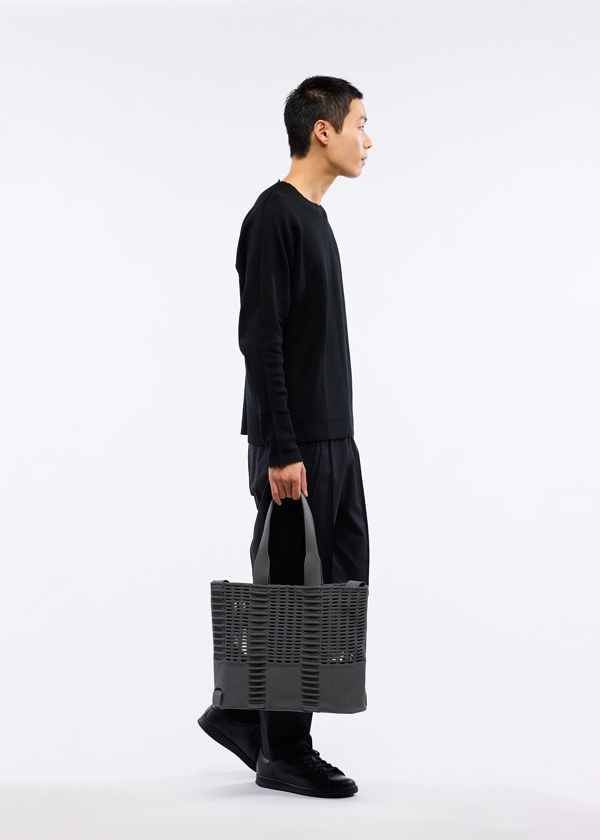 A model wears the GOOD GOODS ISSEY MIYAKE MOKKO MONO bag.
