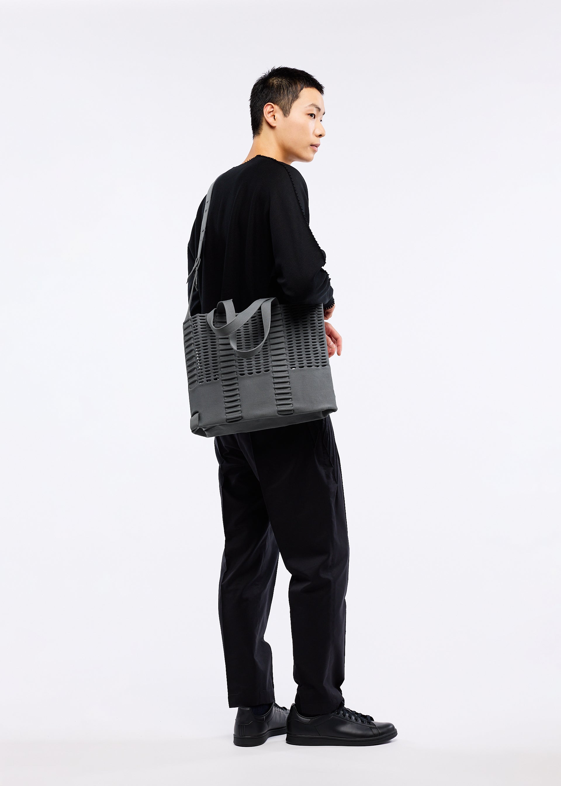 A model wears the GOOD GOODS ISSEY MIYAKE MOKKO MONO bag.