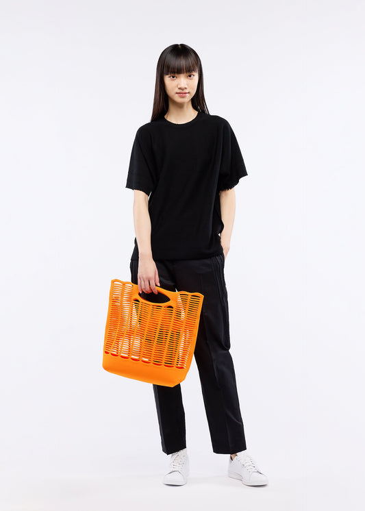 A model wears the GOOD GOODS ISSEY MIYAKE MOKKO S.C. bag.