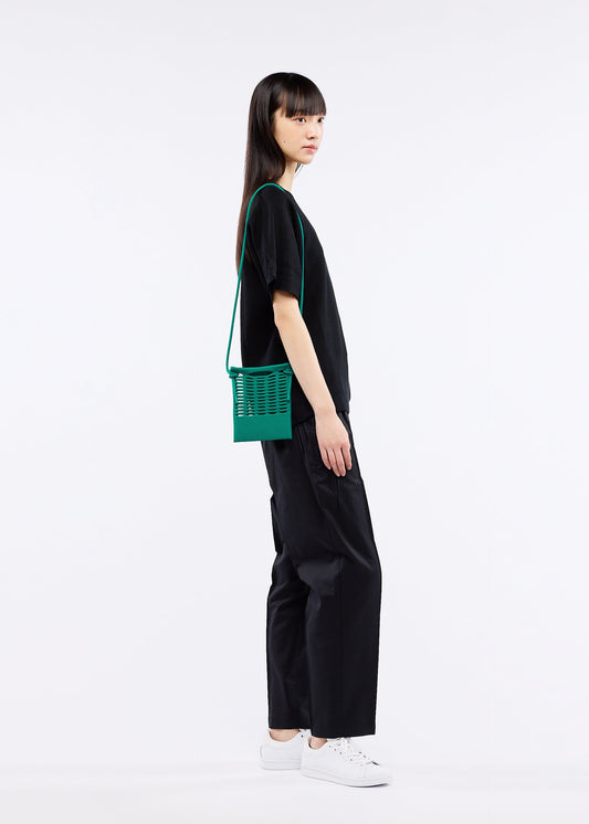 A model wears the GOOD GOODS ISSEY MIYAKE MOKKO S.C. bag.