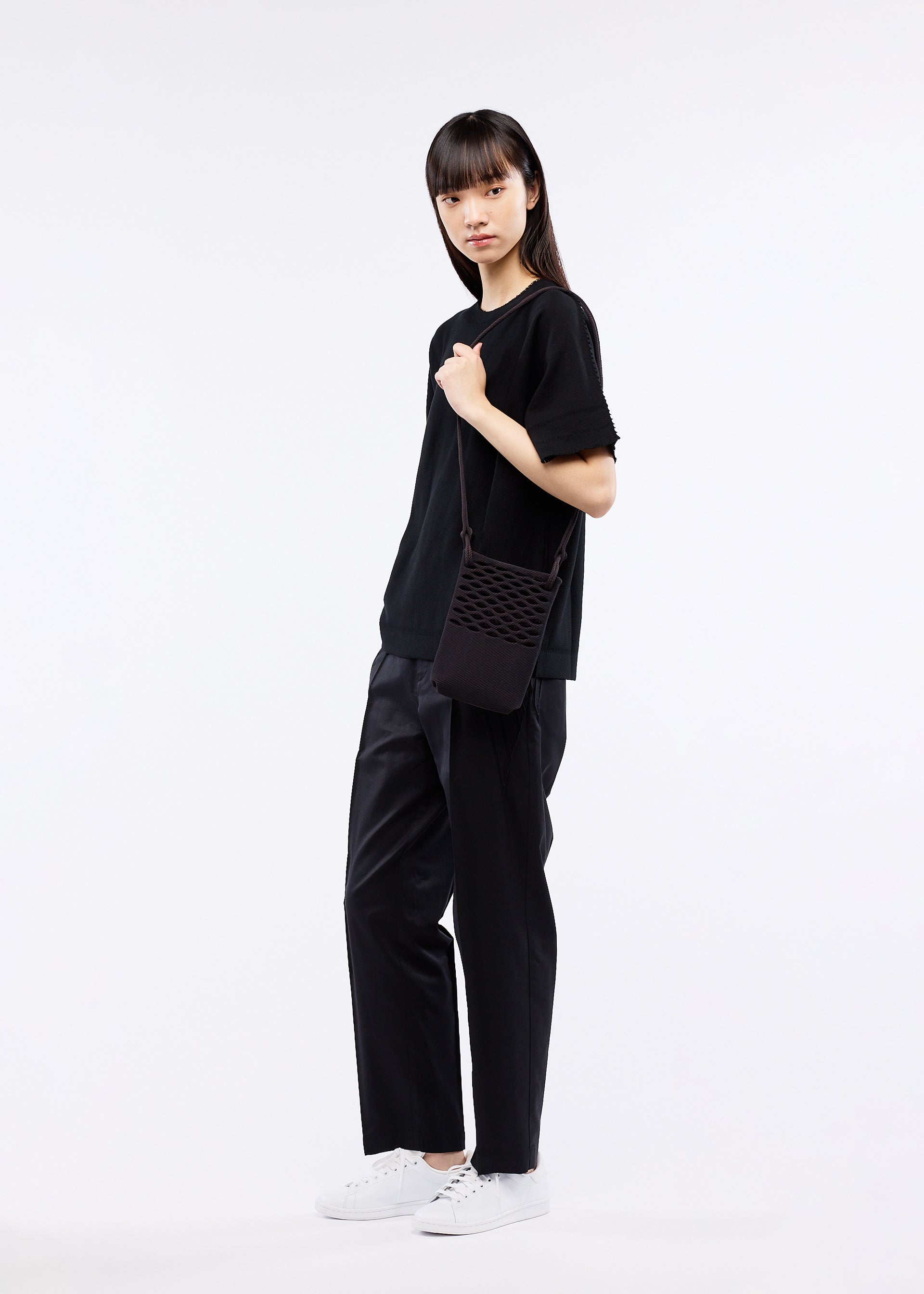 A model wears the GOOD GOODS ISSEY MIYAKE MOKKO BASKET bag.