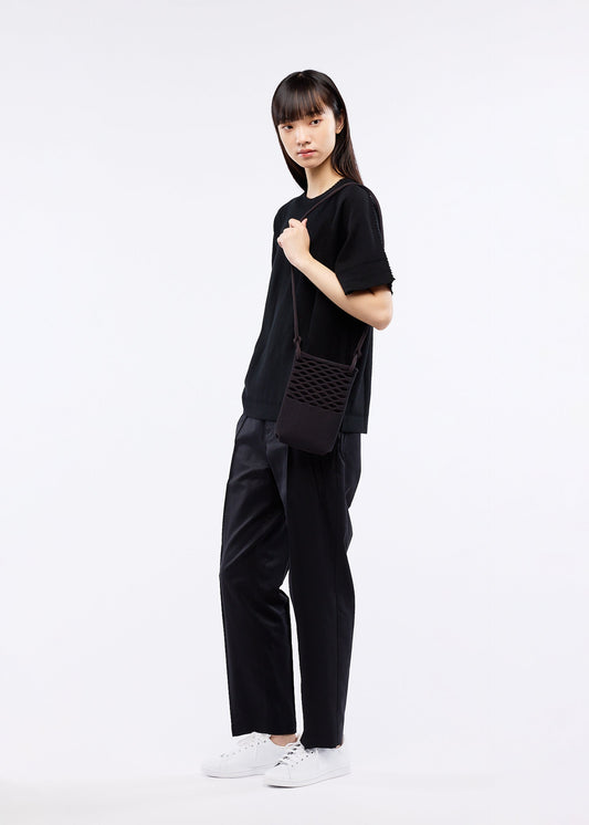 A model wears the GOOD GOODS ISSEY MIYAKE MOKKO BASKET bag.