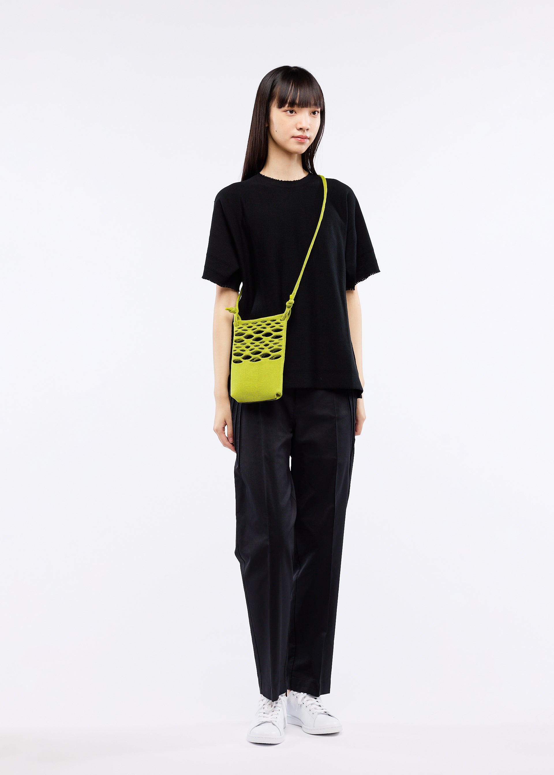 A model wears the GOOD GOODS ISSEY MIYAKE MOKKO BASKET bag.