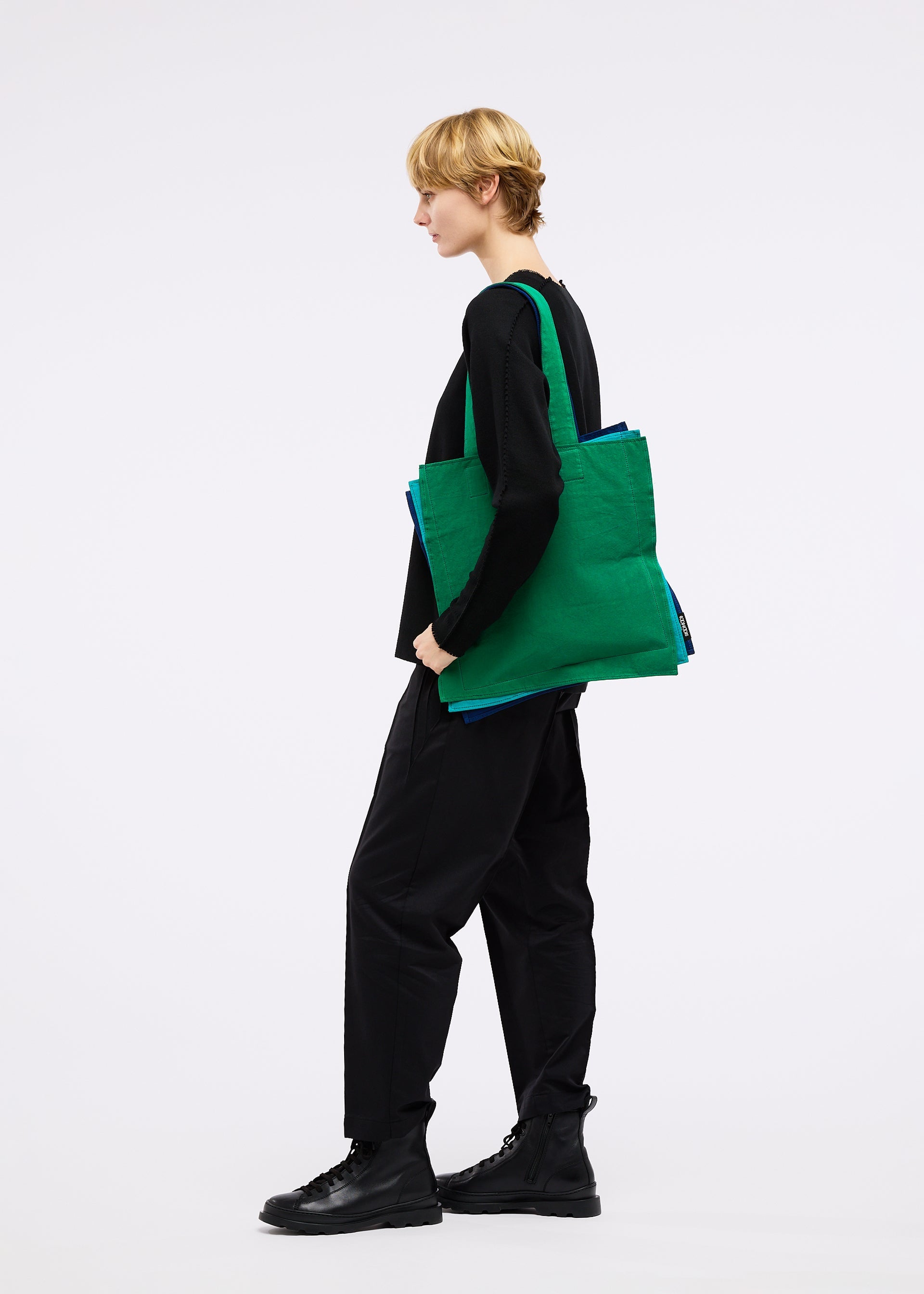 A model wears the GOOD GOODS ISSEY MIYAKE IROGAMI bag.