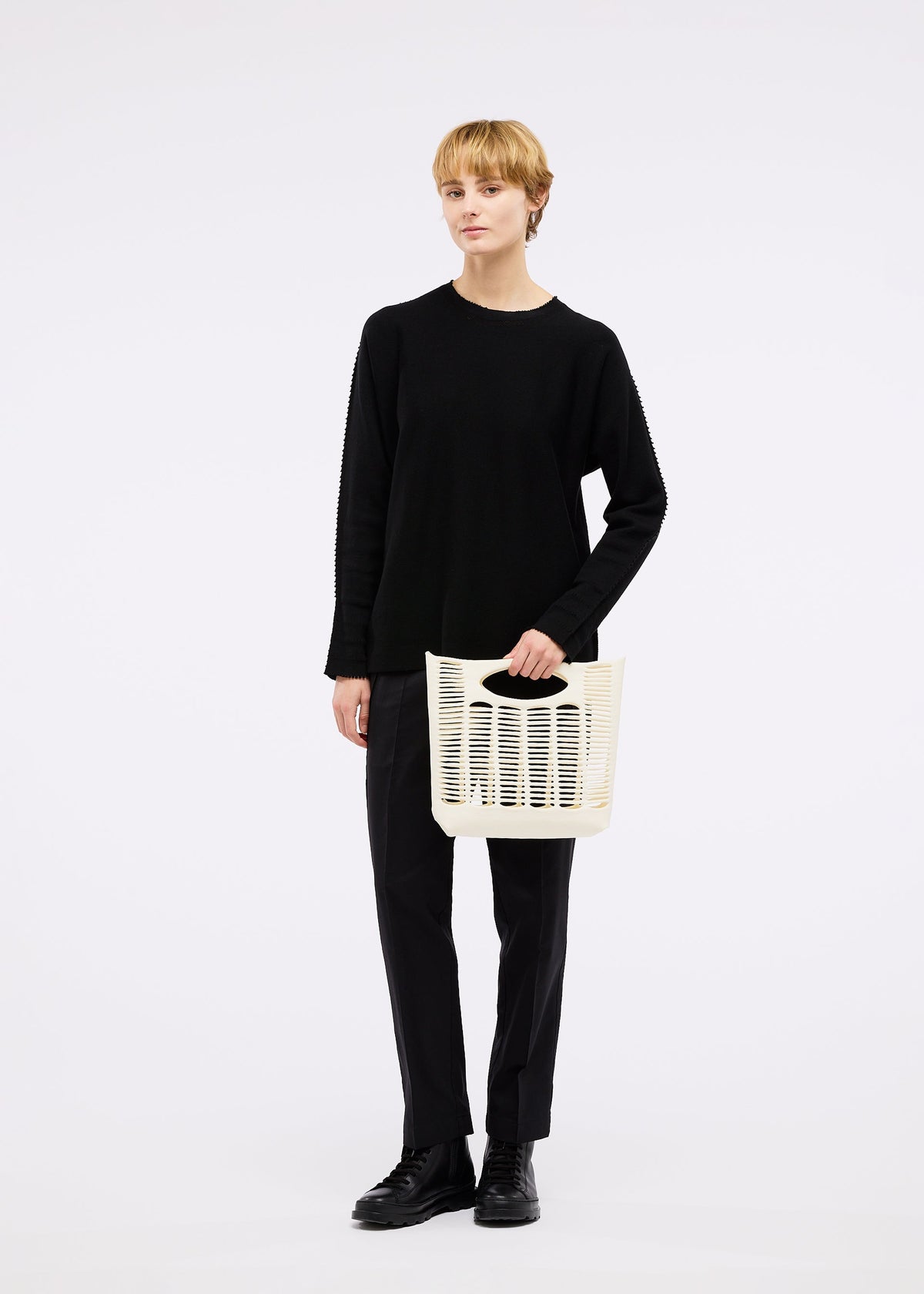 A model wears the GOOD GOODS ISSEY MIYAKE MOKKO bag.