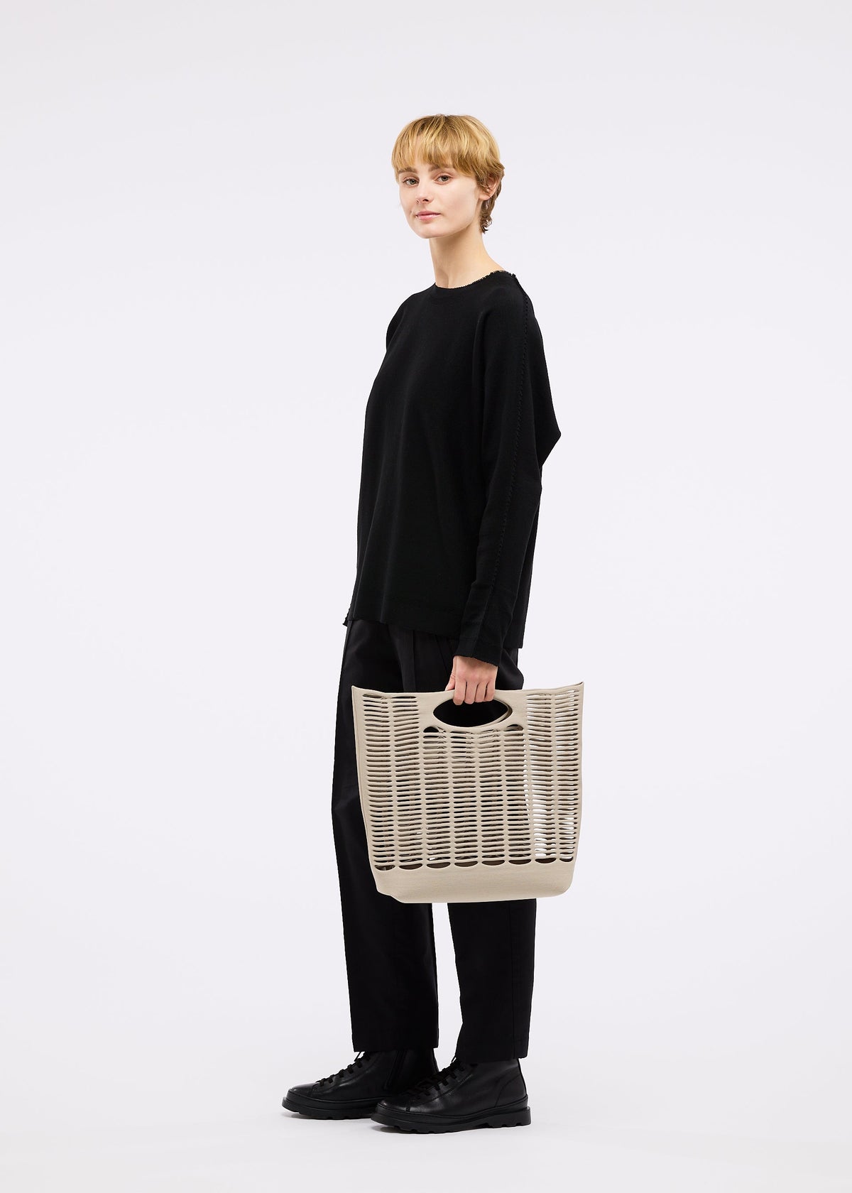 A model wears the GOOD GOODS ISSEY MIYAKE MOKKO bag.