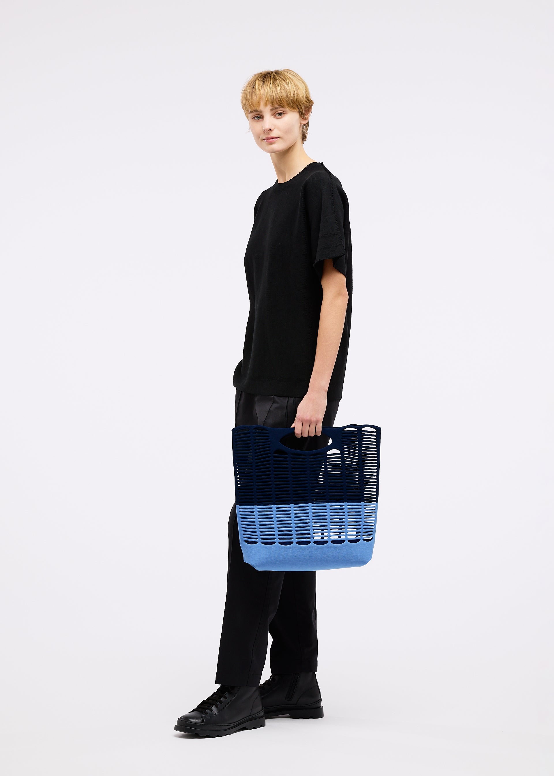 A model wears the GOOD GOODS ISSEY MIYAKE MOKKO BI COLOR bag.