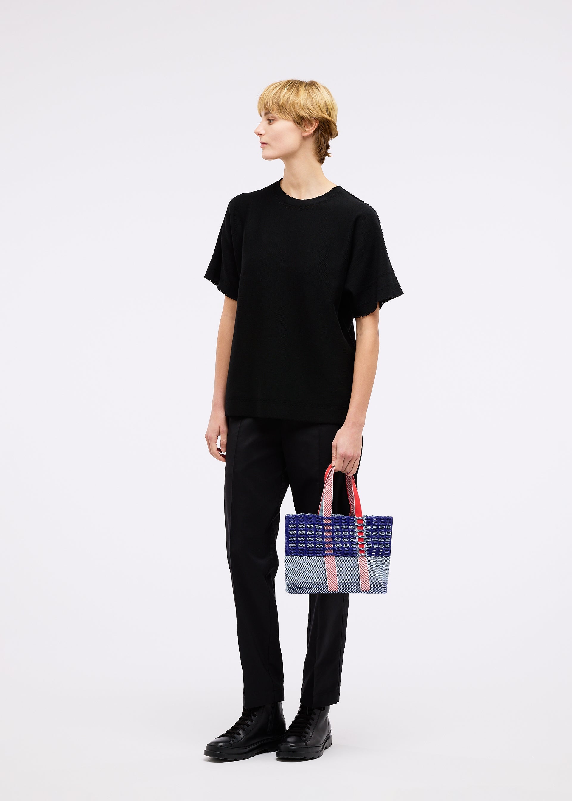A model wears the GOOD GOODS ISSEY MIYAKE MOKKO TOTE MIX bag.