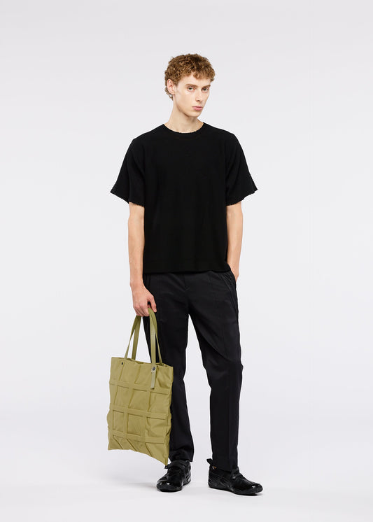 A model wears the GOOD GOODS ISSEY MIYAKE GRID bag.