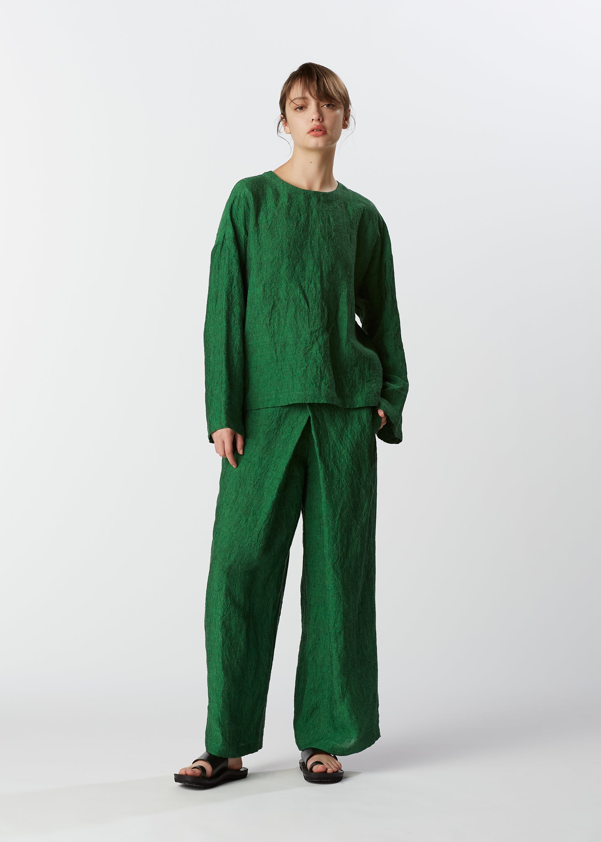 A model wears the HAAT GLOSSY LINEN trousers.
