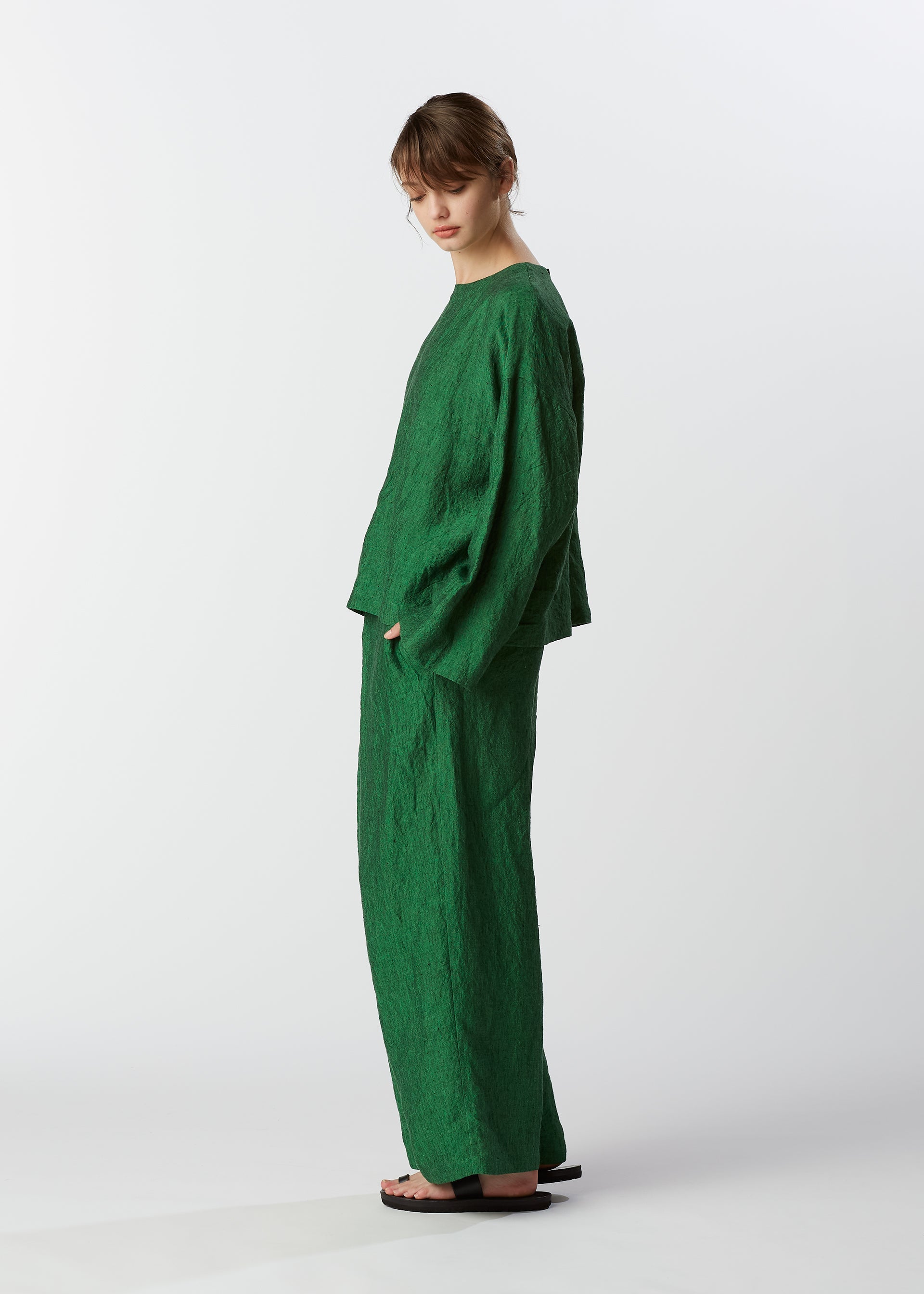 A model wears the HAAT GLOSSY LINEN trousers.