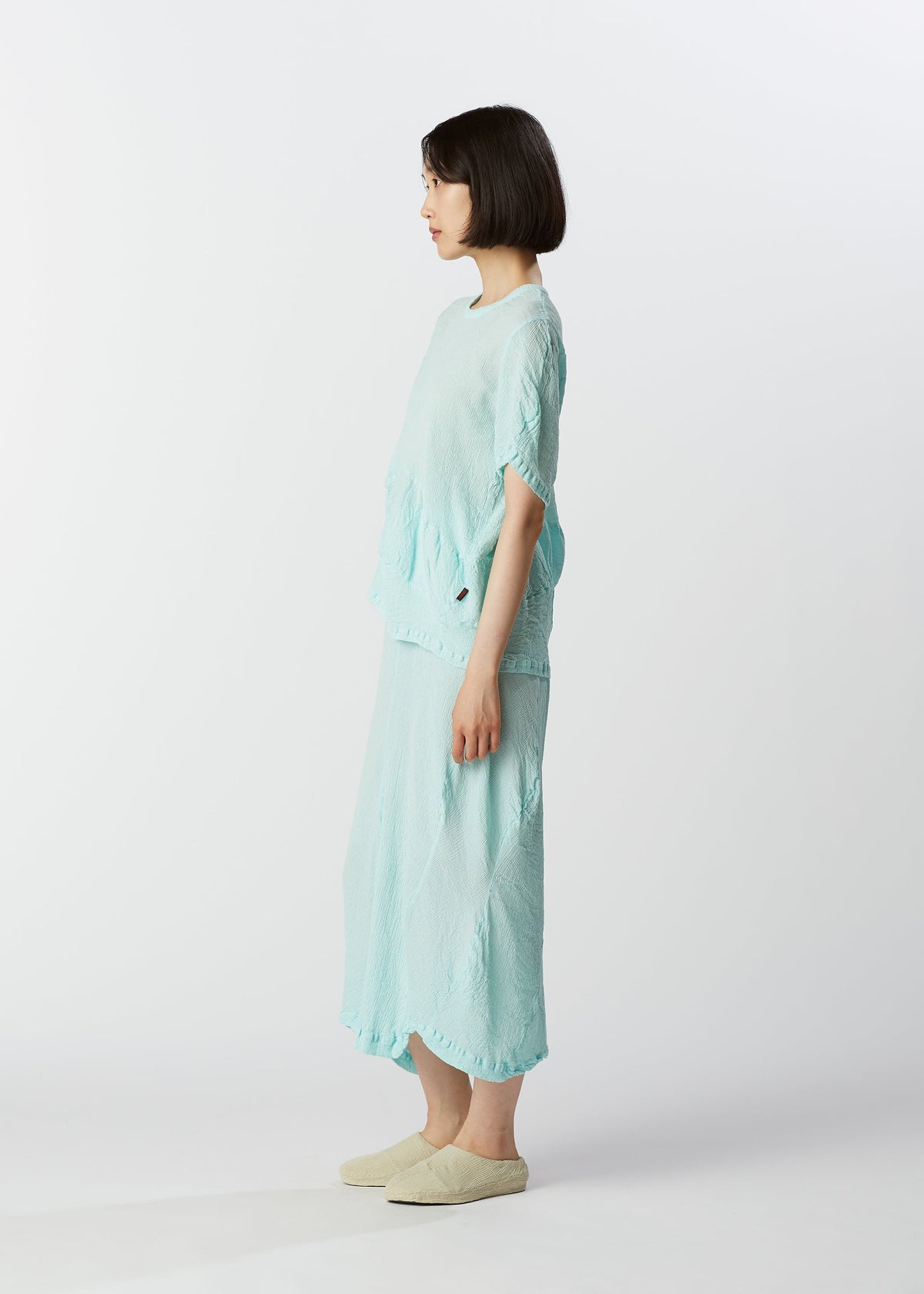 A model wears the HAAT KYO CHIJIMI WAVY skirt.