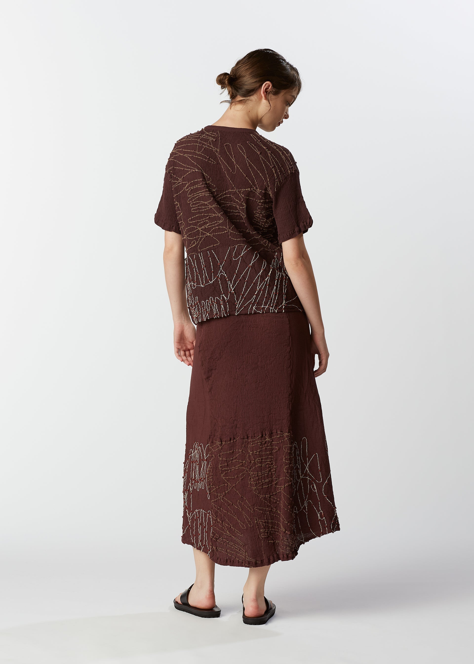 A model wears the HAAT KYO CHIJIMI HOTARU shirt.