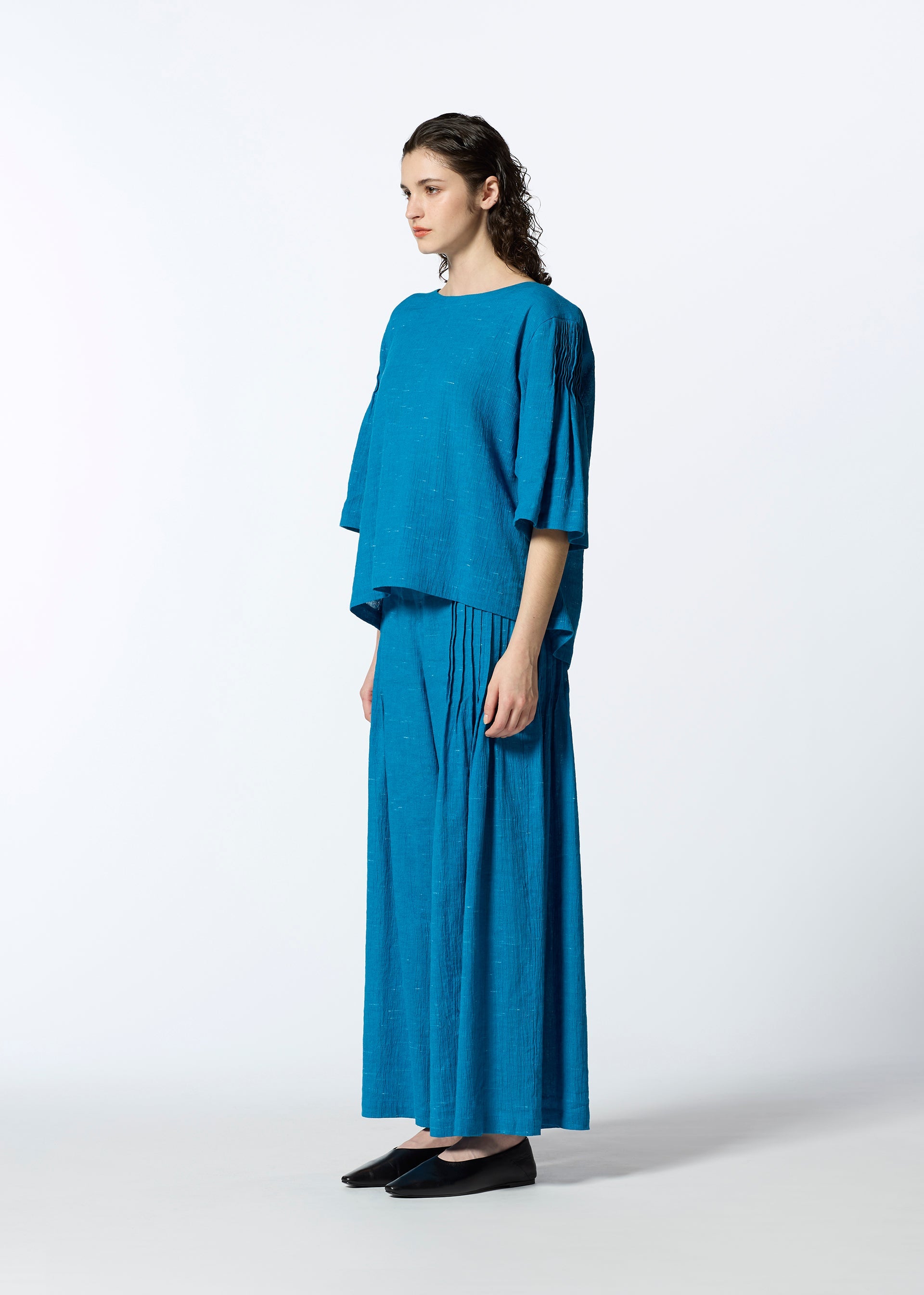 A model wears the HAAT PINTUCKING trousers.