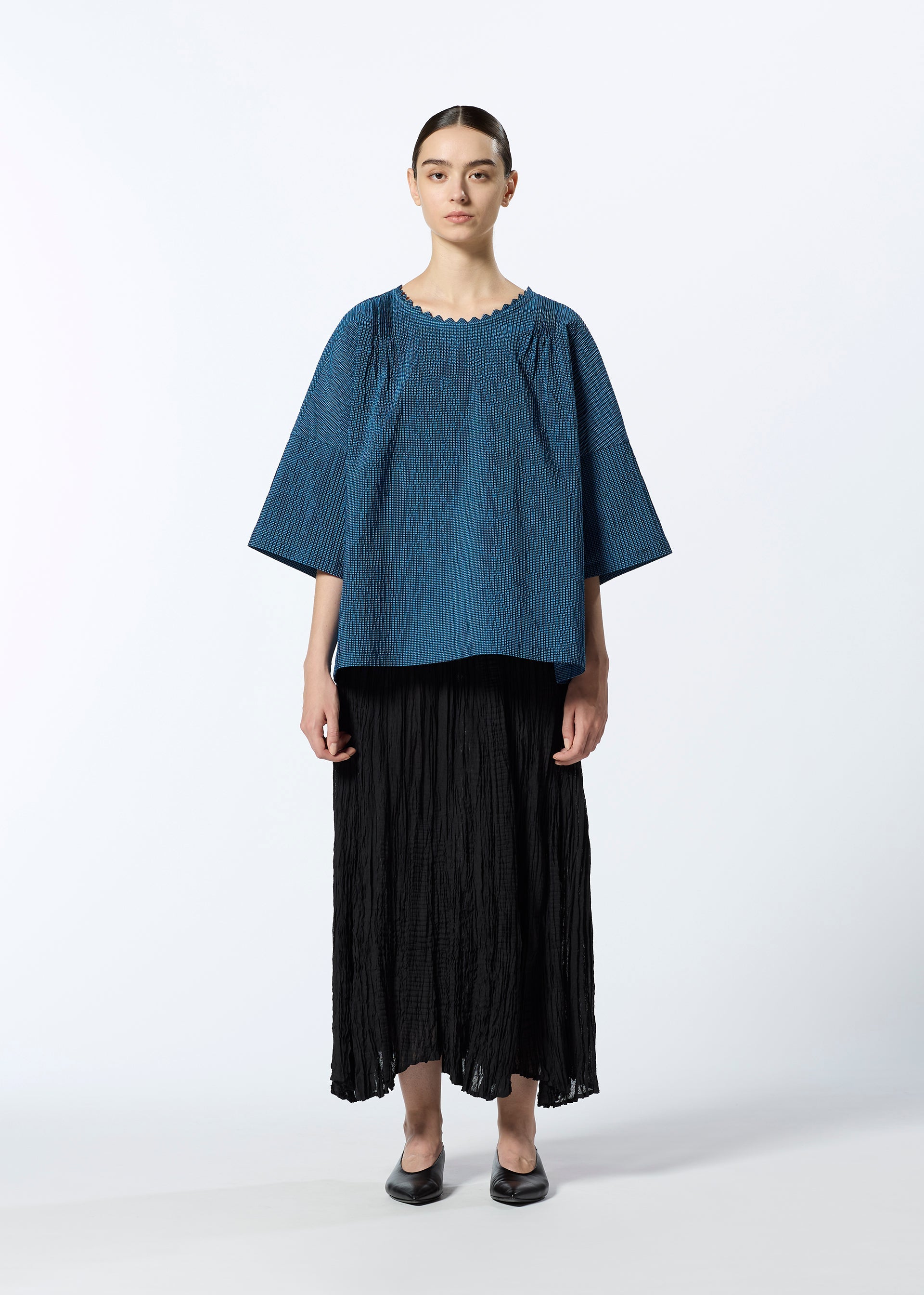 A model wears the HAAT TATSUMAKI SKIRT skirt.