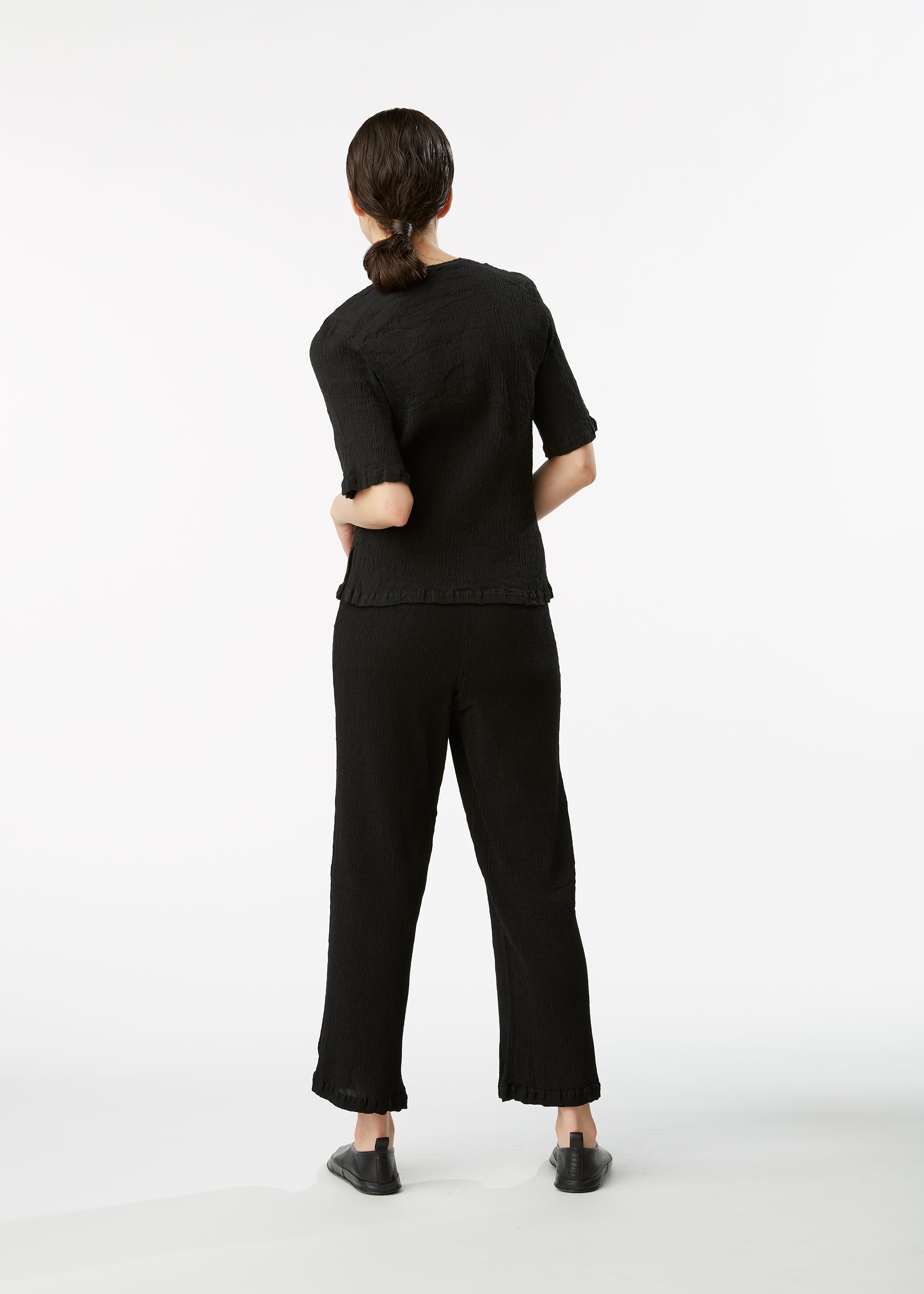 A model wears the HAAT KYO CHIJIMI BASIC trousers