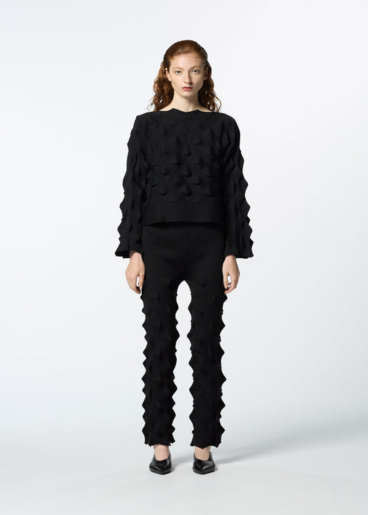 A model wears the HAAT ZIG ZAG KNIT trousers.