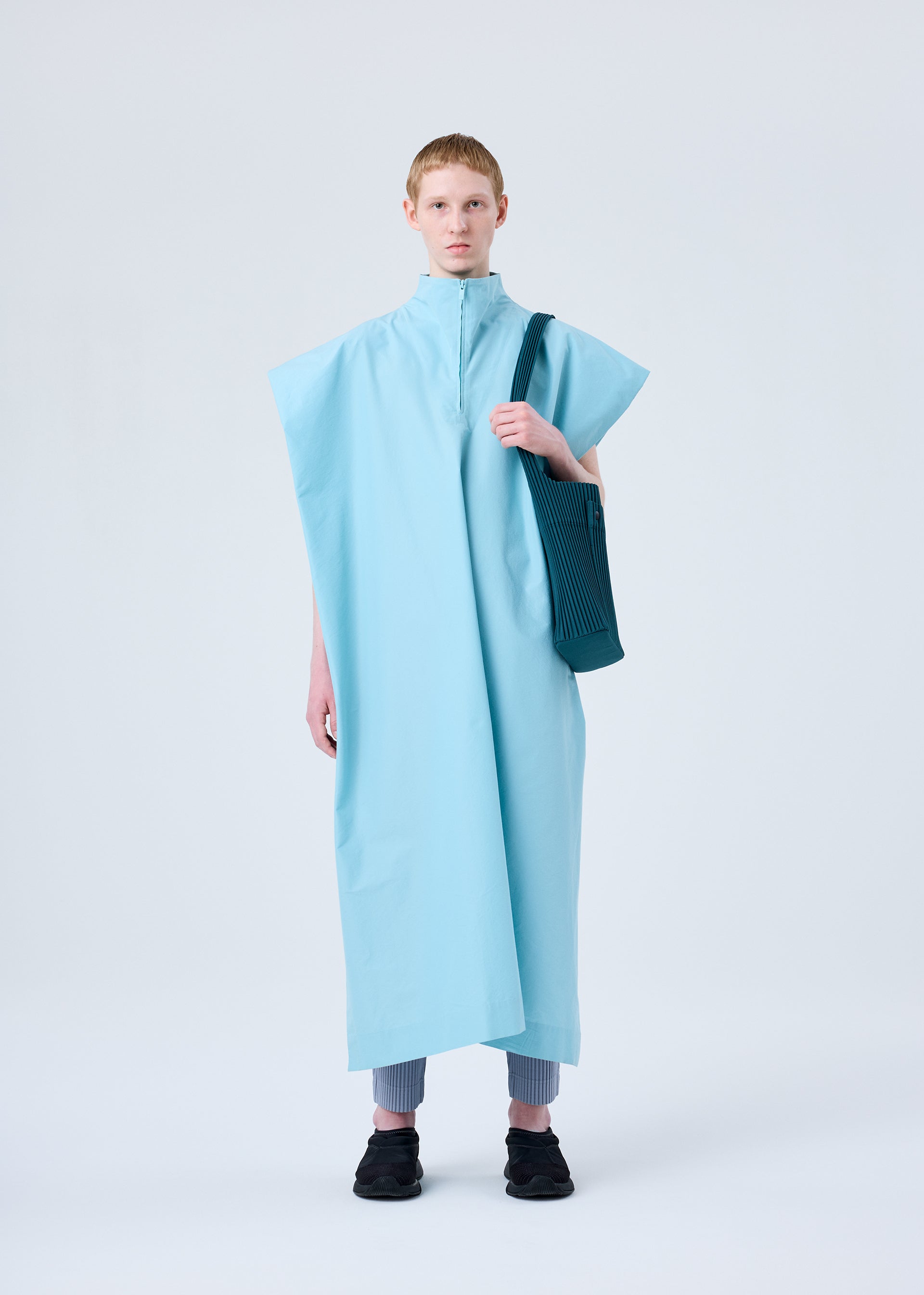 A model wears the HOMME PLISSÉ ISSEY MIYAKE UTILITY bag