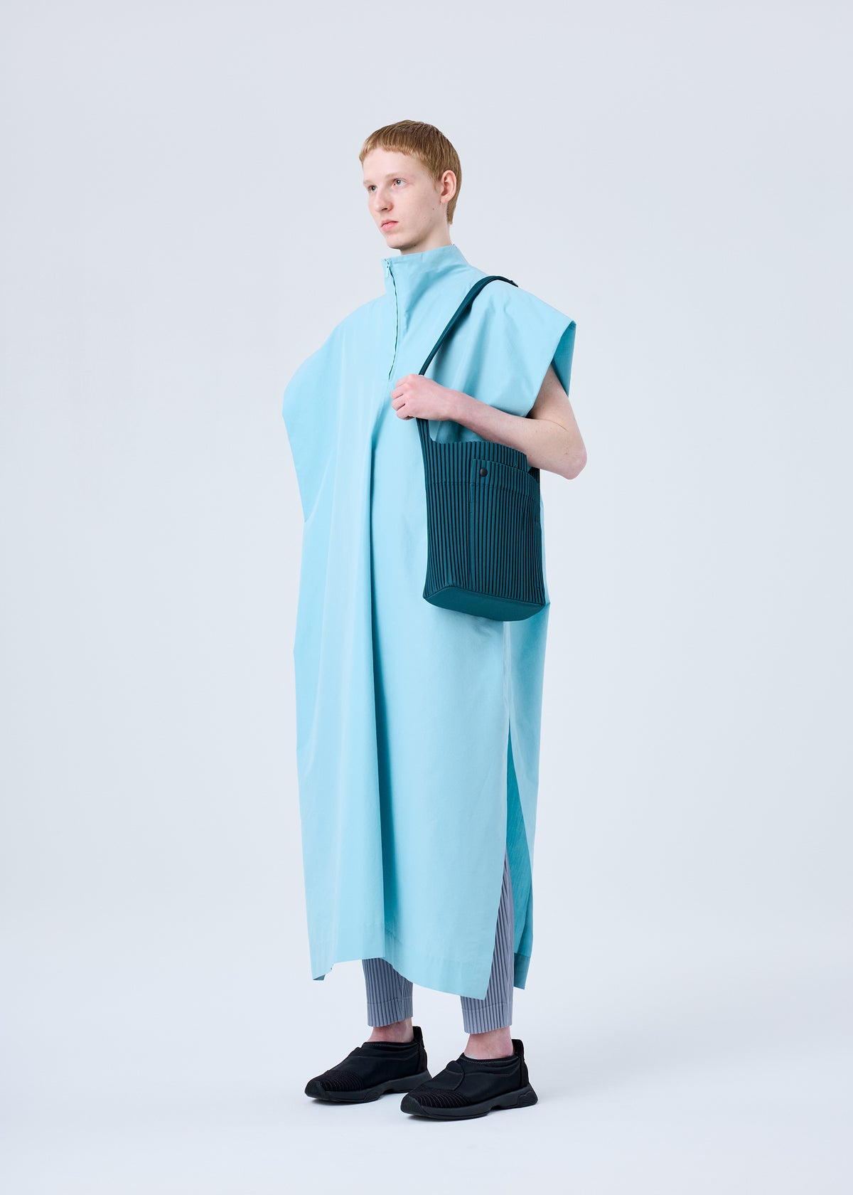 A model wears the HOMME PLISSÉ ISSEY MIYAKE UTILITY bag