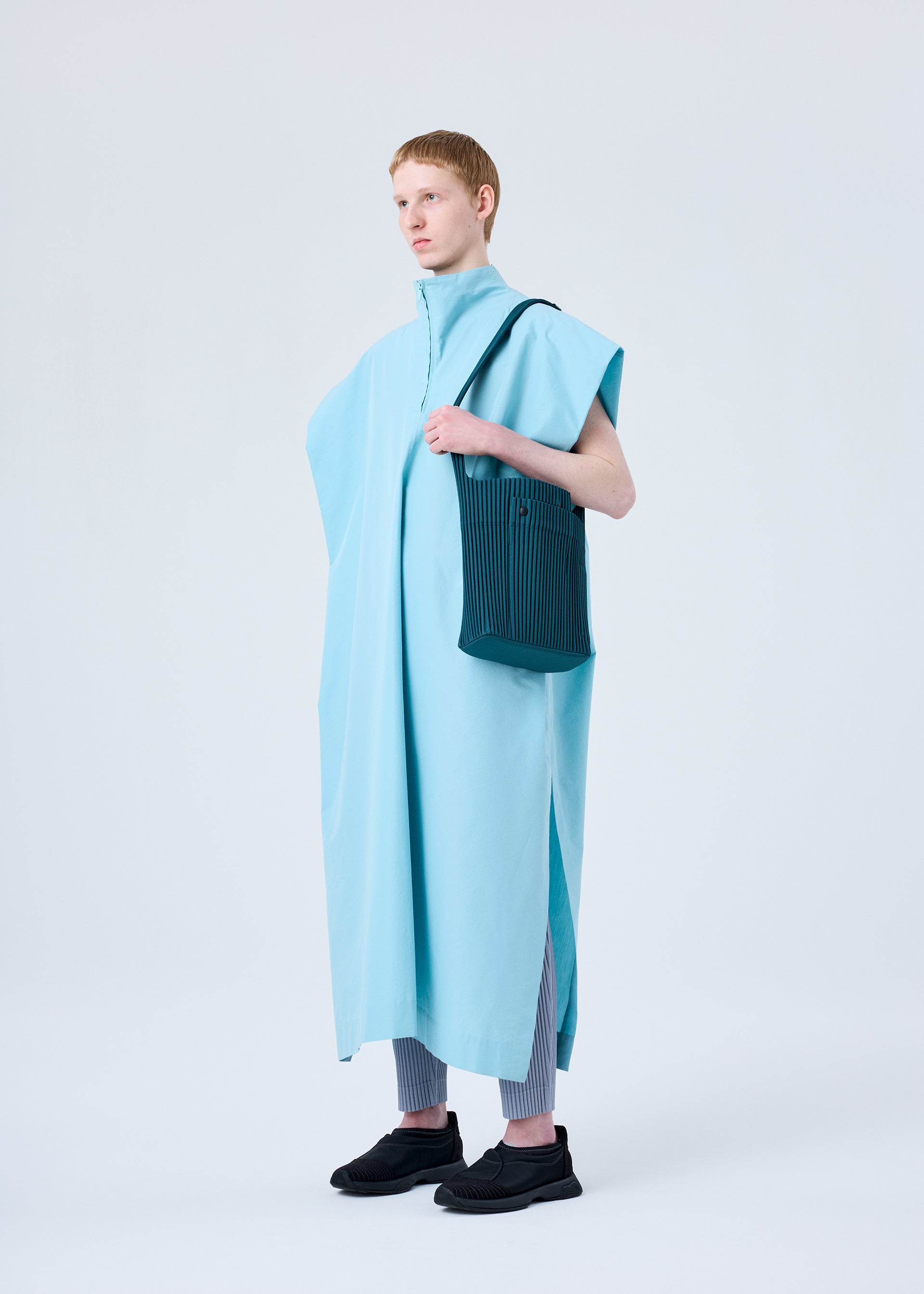 A model wears the HOMME PLISSÉ ISSEY MIYAKE UTILITY bag