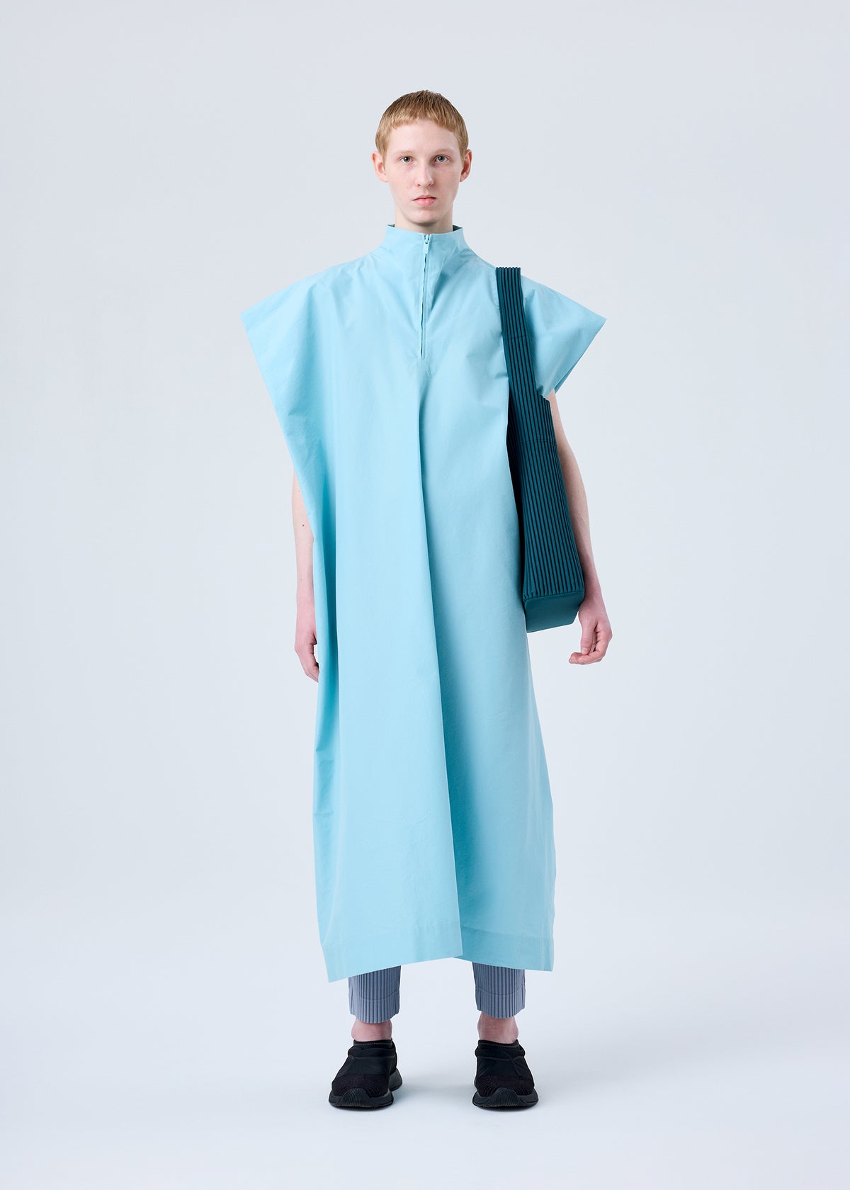 A model wears the HOMME PLISSÉ ISSEY MIYAKE UTILITY bag