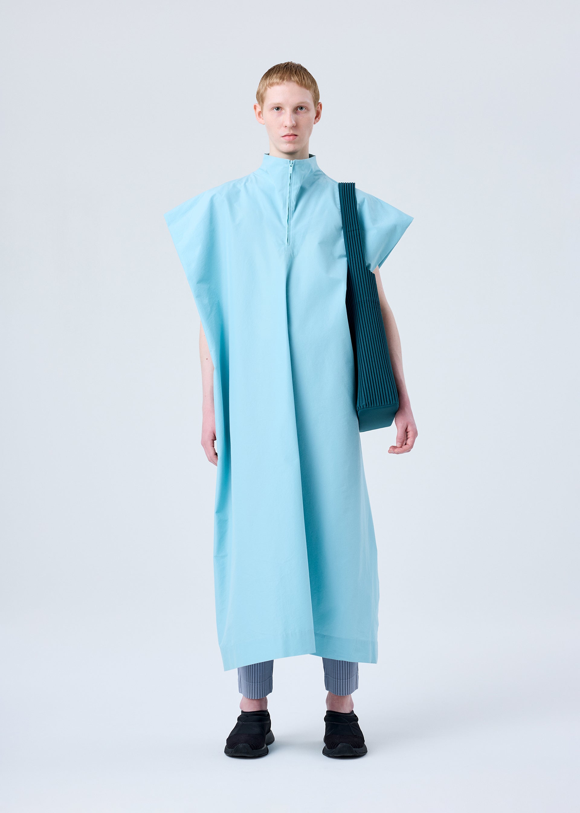 A model wears the HOMME PLISSÉ ISSEY MIYAKE UTILITY bag