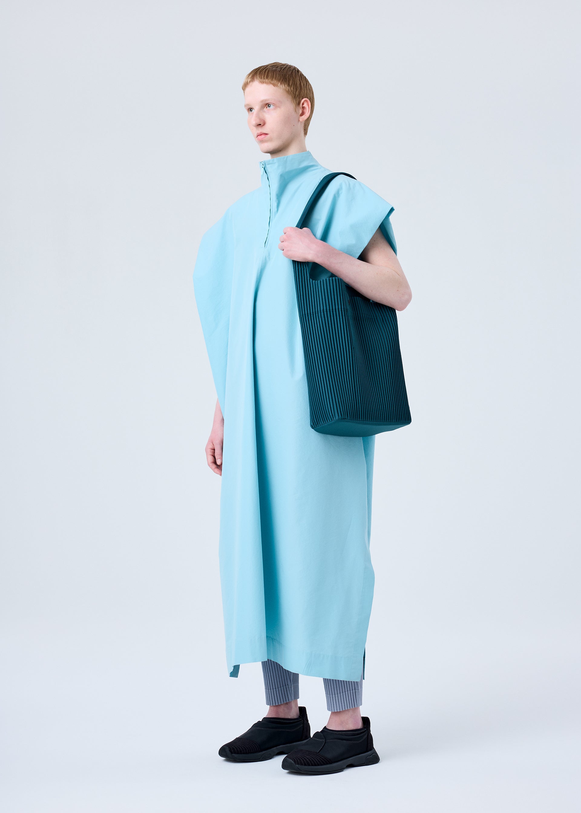 A model wears the HOMME PLISSÉ ISSEY MIYAKE UTILITY bag