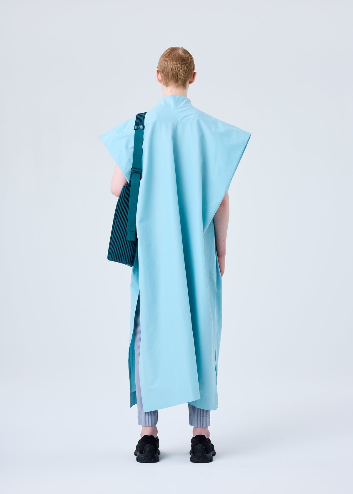 A model wears the HOMME PLISSÉ ISSEY MIYAKE UTILITY bag