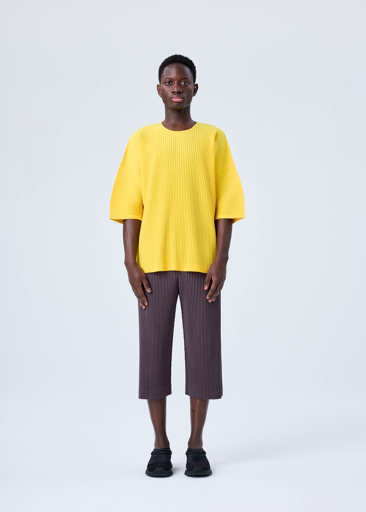 A model wears the HOMME PLISSÉ ISSEY MIYAKE MC JULY top