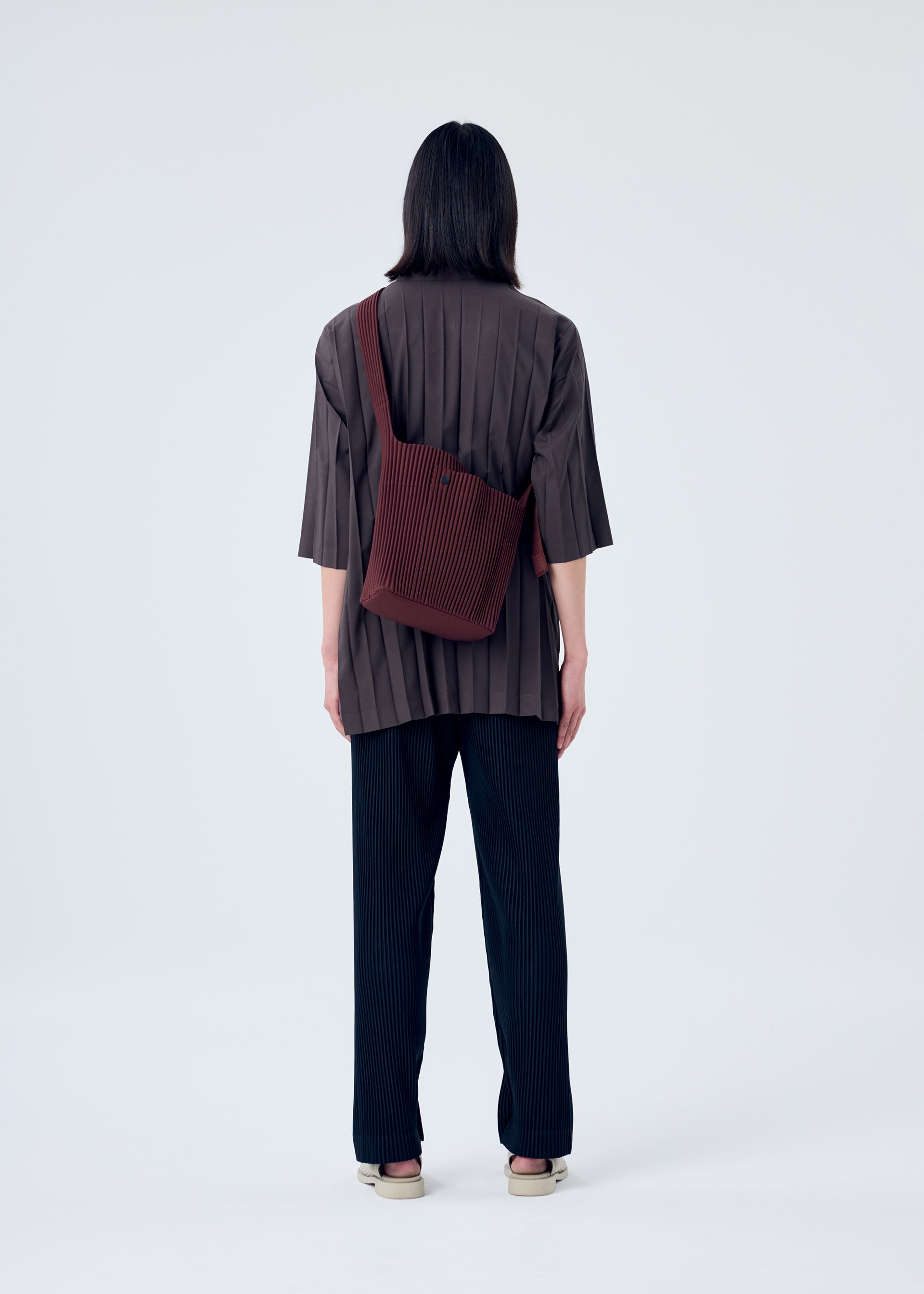 A model wears the HOMME PLISSÉ ISSEY MIYAKE UTILITY bag.
