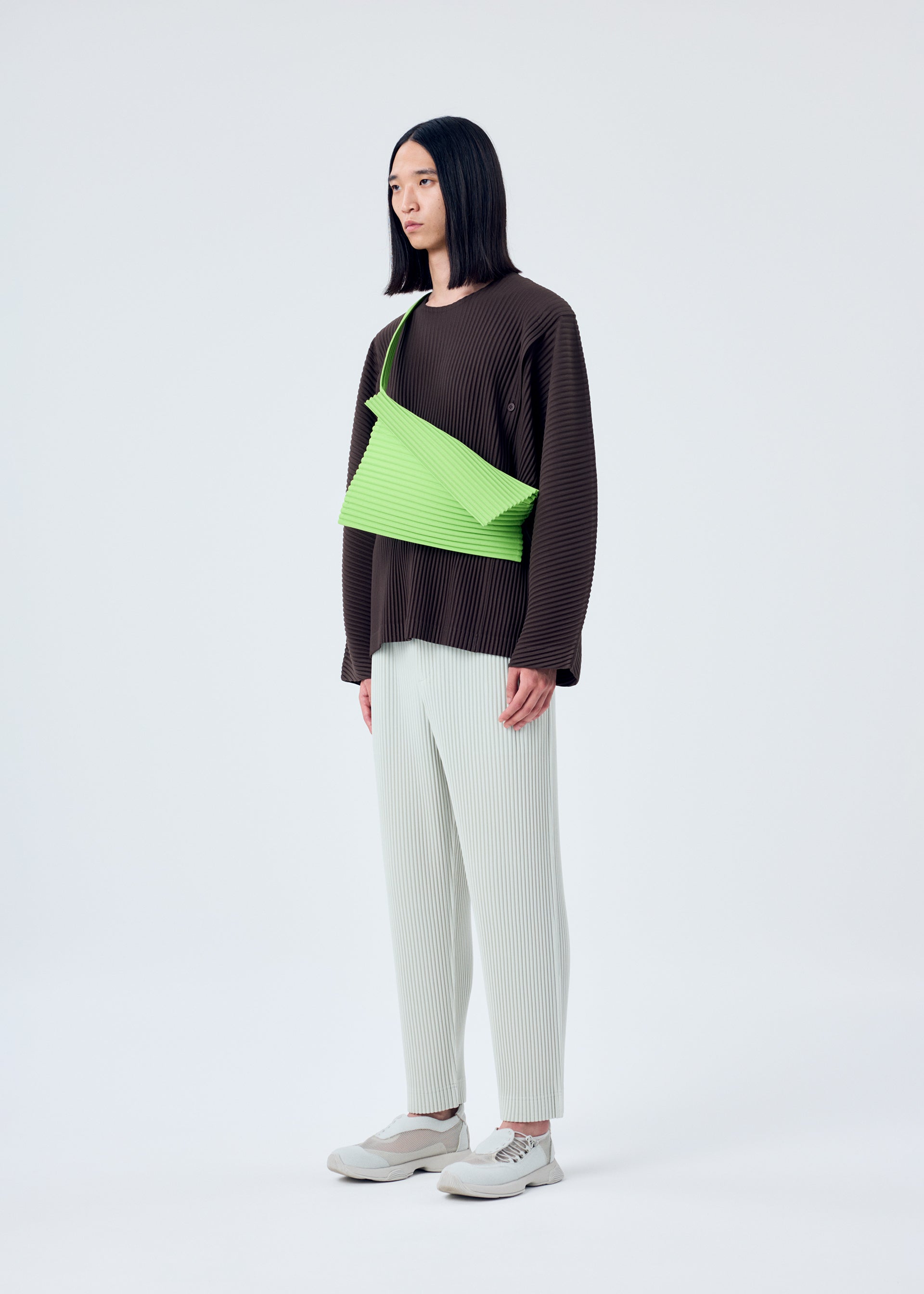 A model wears the HOMME PLISSÉ ISSEY MIYAKE OVERLAP bag.