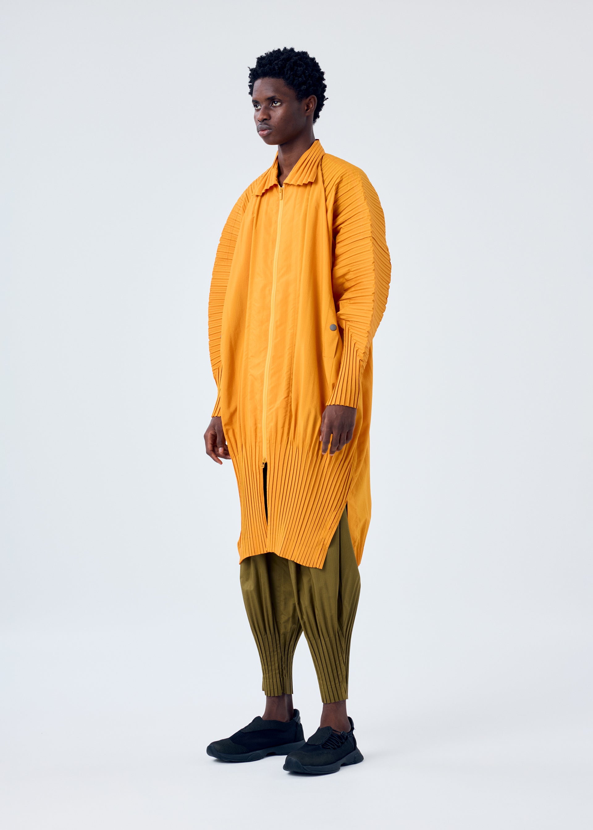 A model wears the HOMME PLISSÉ ISSEY MIYAKE CASCADE coat.