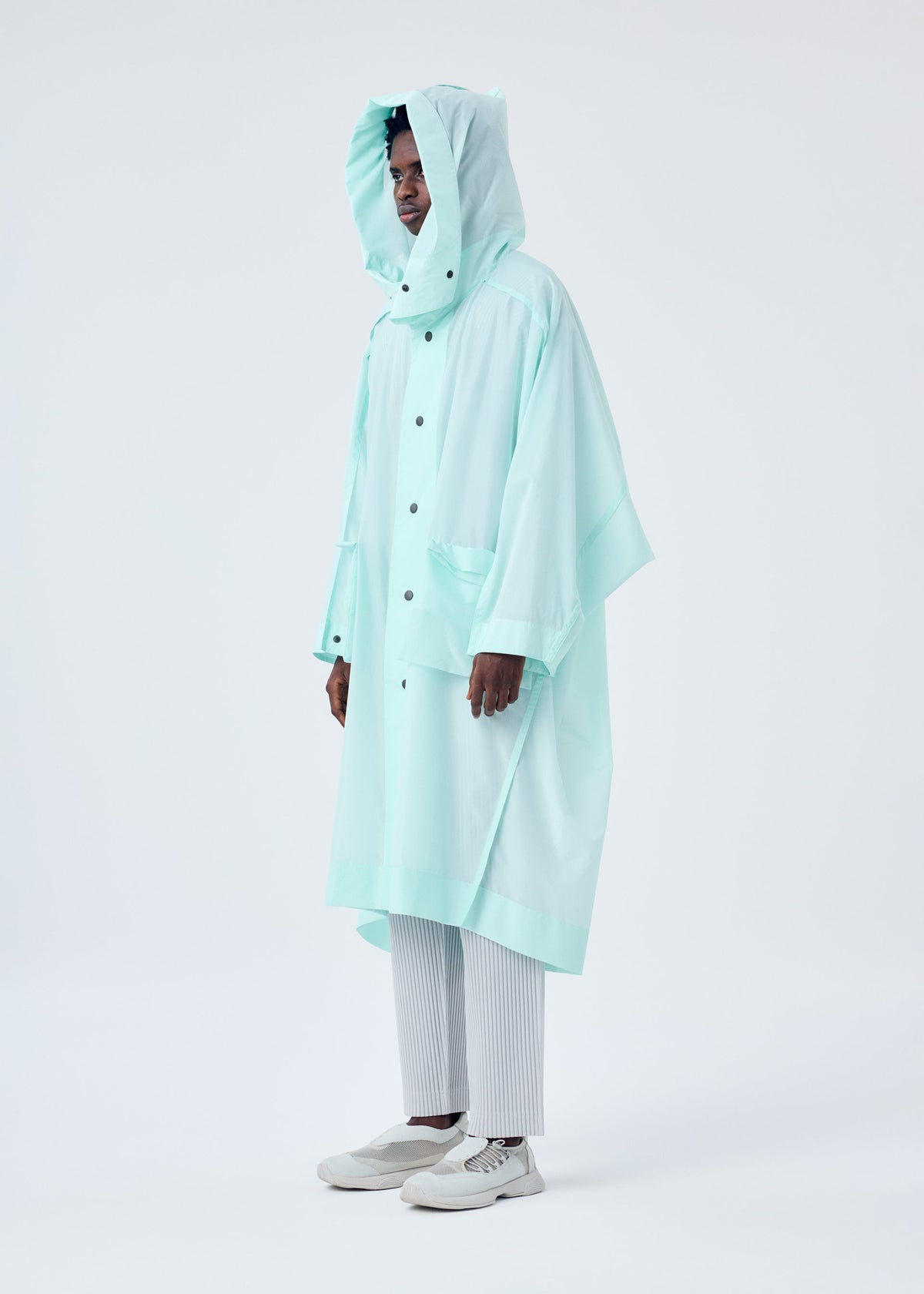 A model wears the HOMME PLISSÉ ISSEY MIYAKE KITE COAT coat.