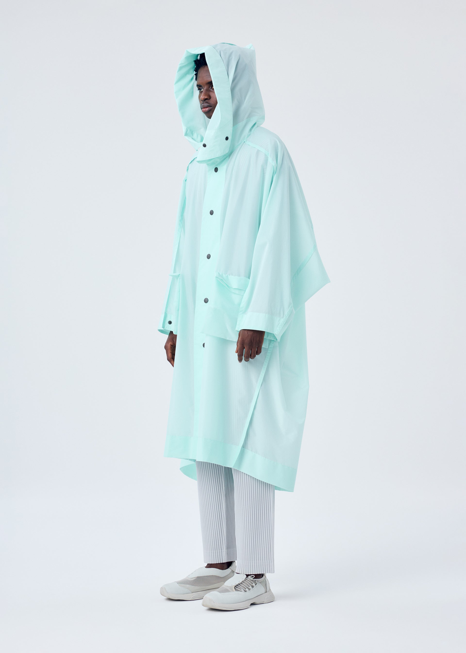 A model wears the HOMME PLISSÉ ISSEY MIYAKE KITE COAT coat.