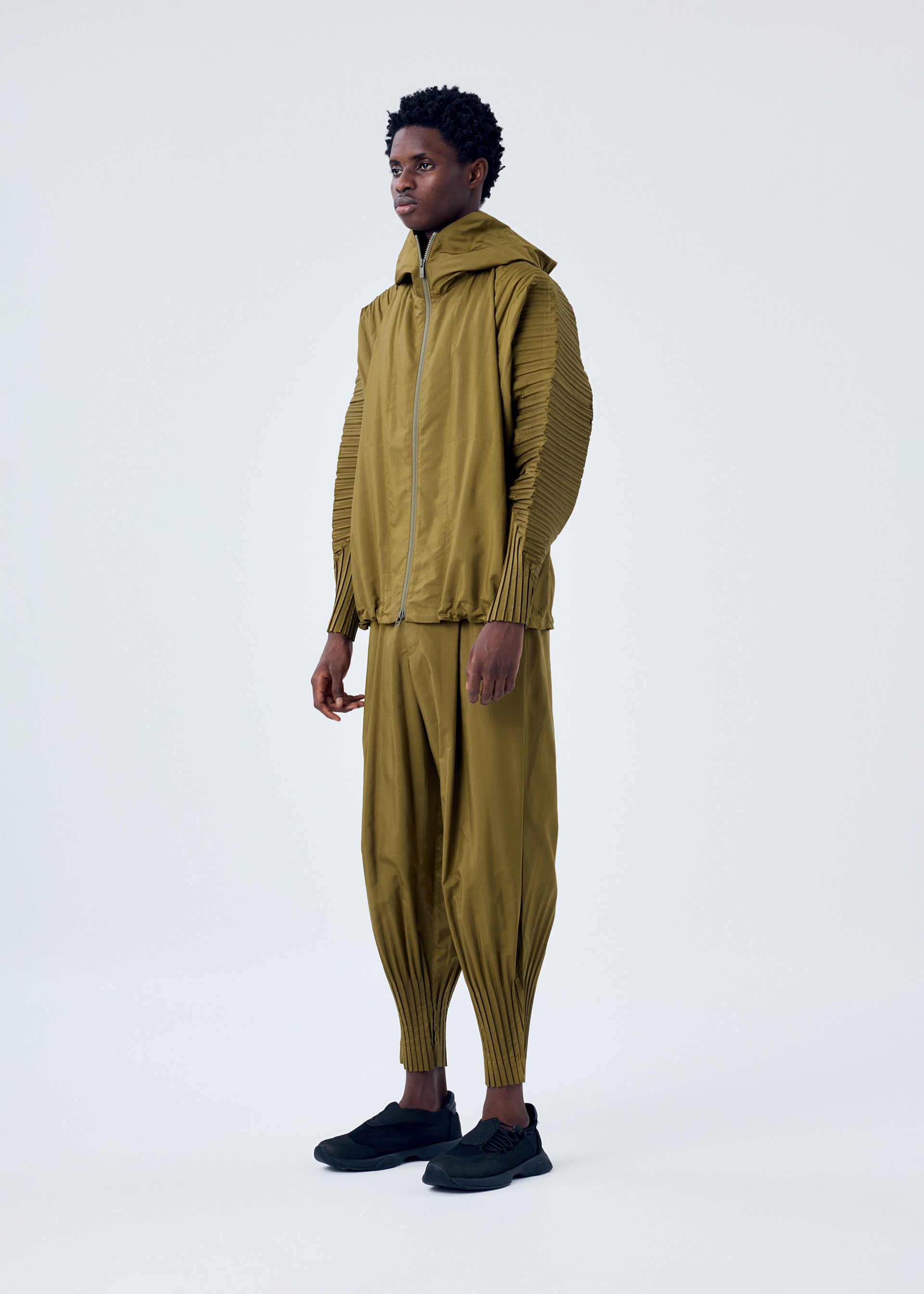 A model wears the HOMME PLISSÉ ISSEY MIYAKE CASCADE jacket.