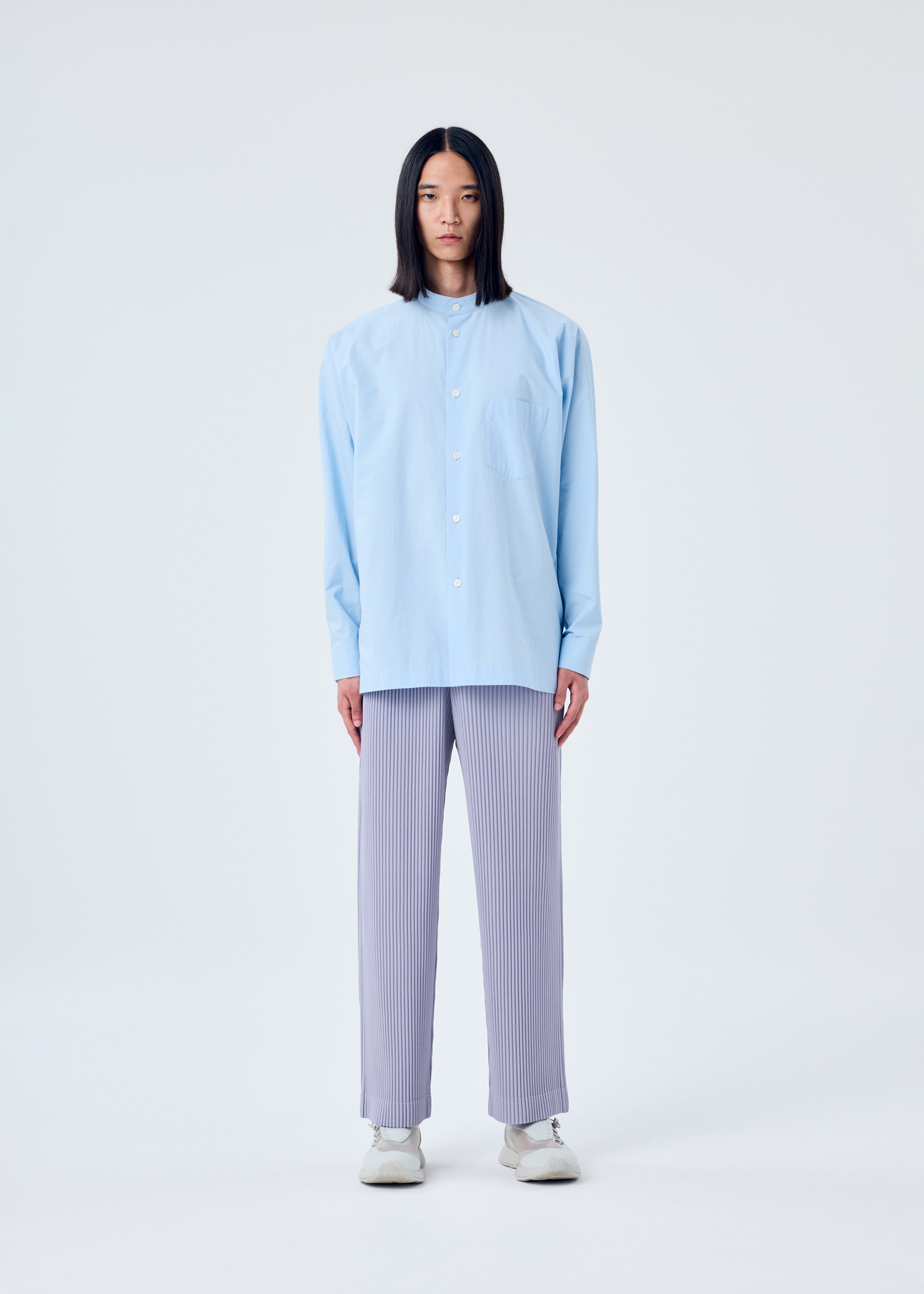 A model wears the HOMME PLISSÉ ISSEY MIYAKE STREAMLINE SHIRT shirt.