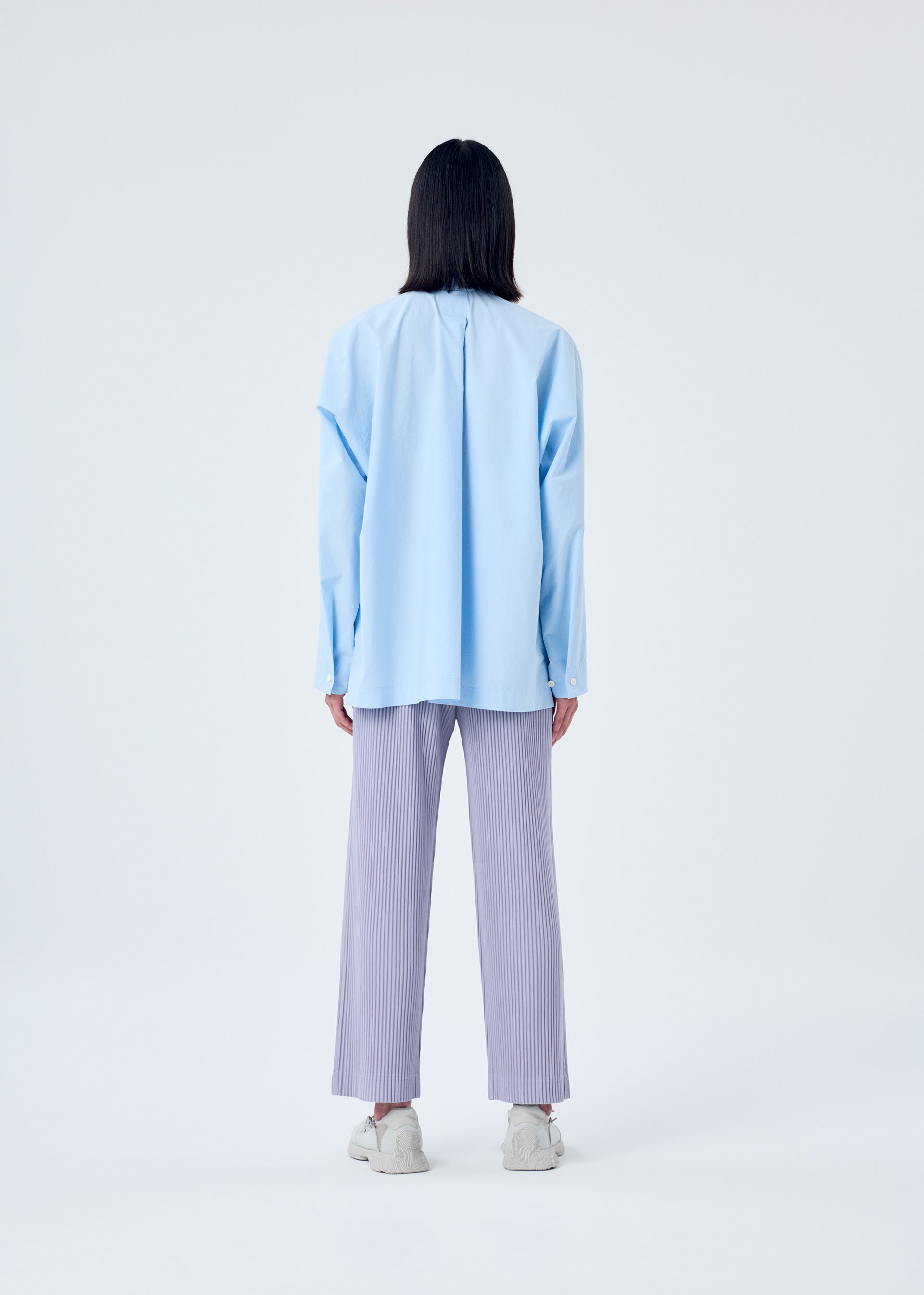 A model wears the HOMME PLISSÉ ISSEY MIYAKE STREAMLINE SHIRT shirt.